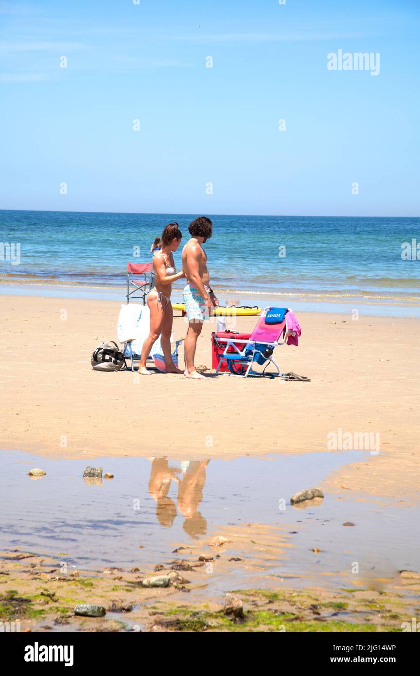 Un couple à la plage sur Cape Cod, Massachusetts, États-Unis - application de crème solaire Banque D'Images