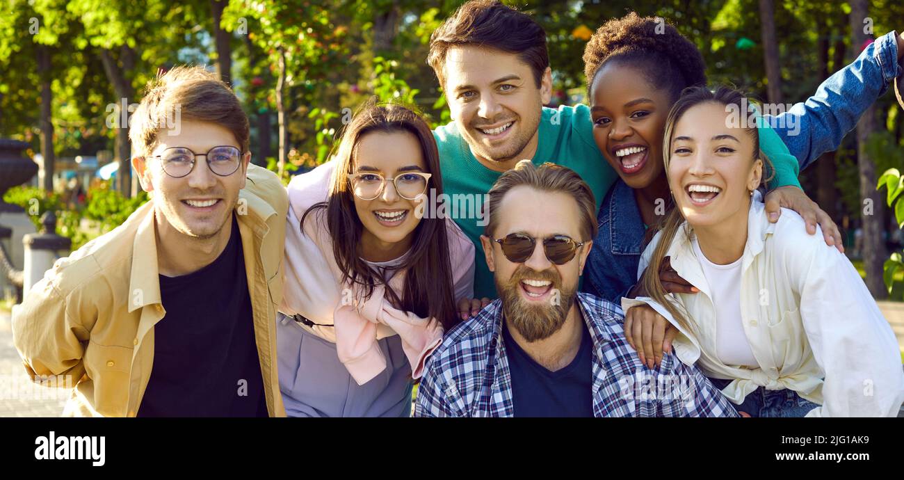 Joyeux jeunes amis multiethniques hommes et femme souriant après la promenade de rue d'été, portrait de groupe Banque D'Images