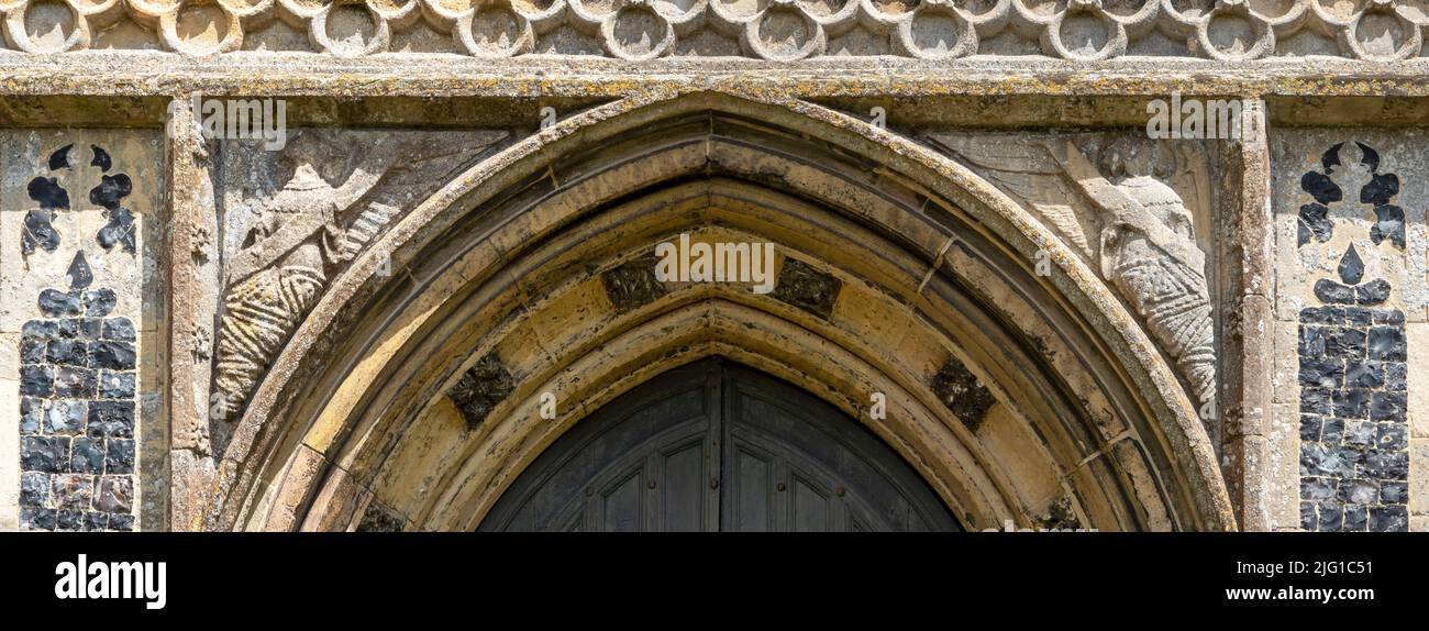 Des anges de pierre sculptés dans les coins de cadre de porte de l'église All Saints, Laxfield, Suffolk Banque D'Images