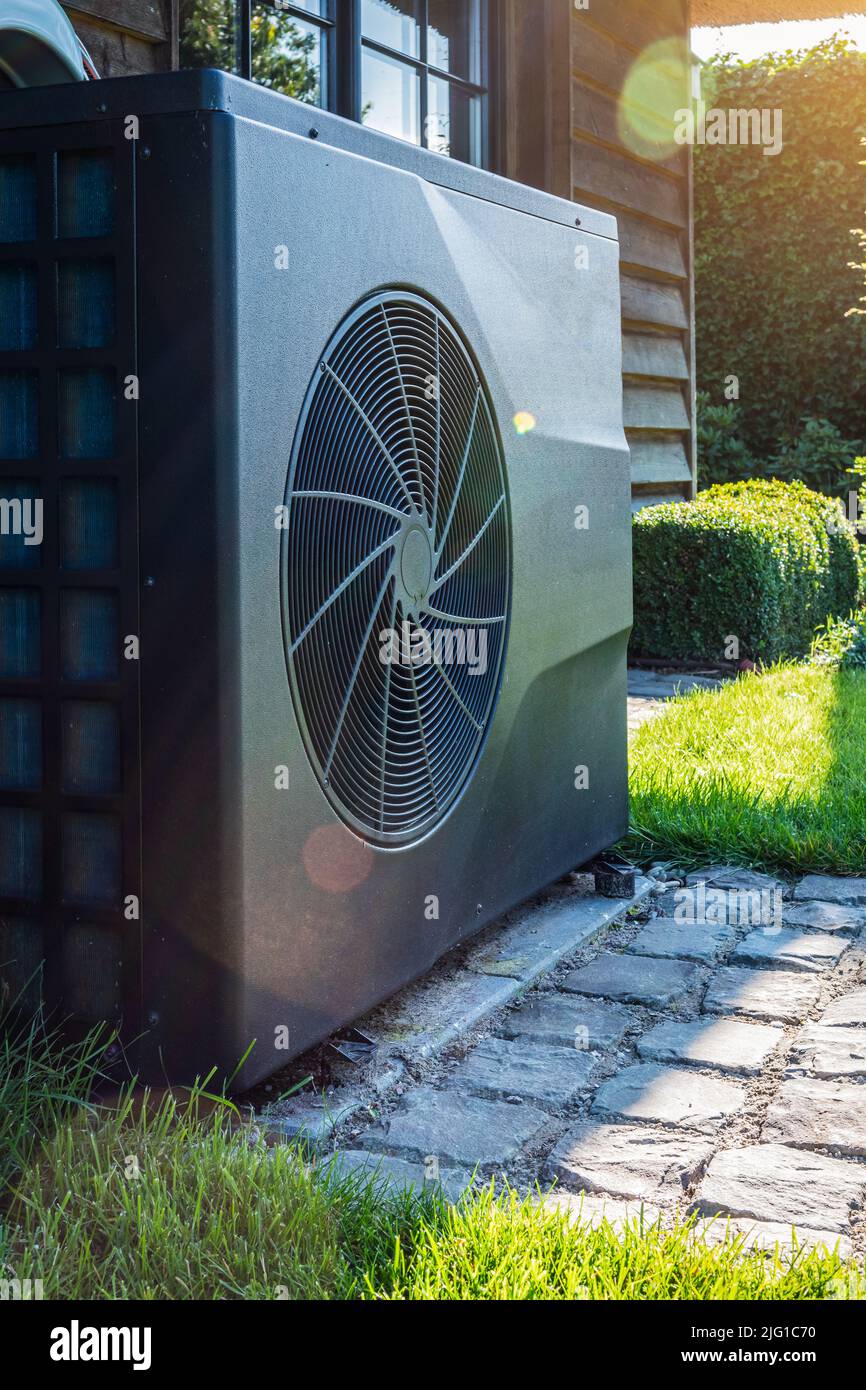 Pompe à chaleur à convertisseur complet près de la maison dans le jardin. Gros plan. Banque D'Images