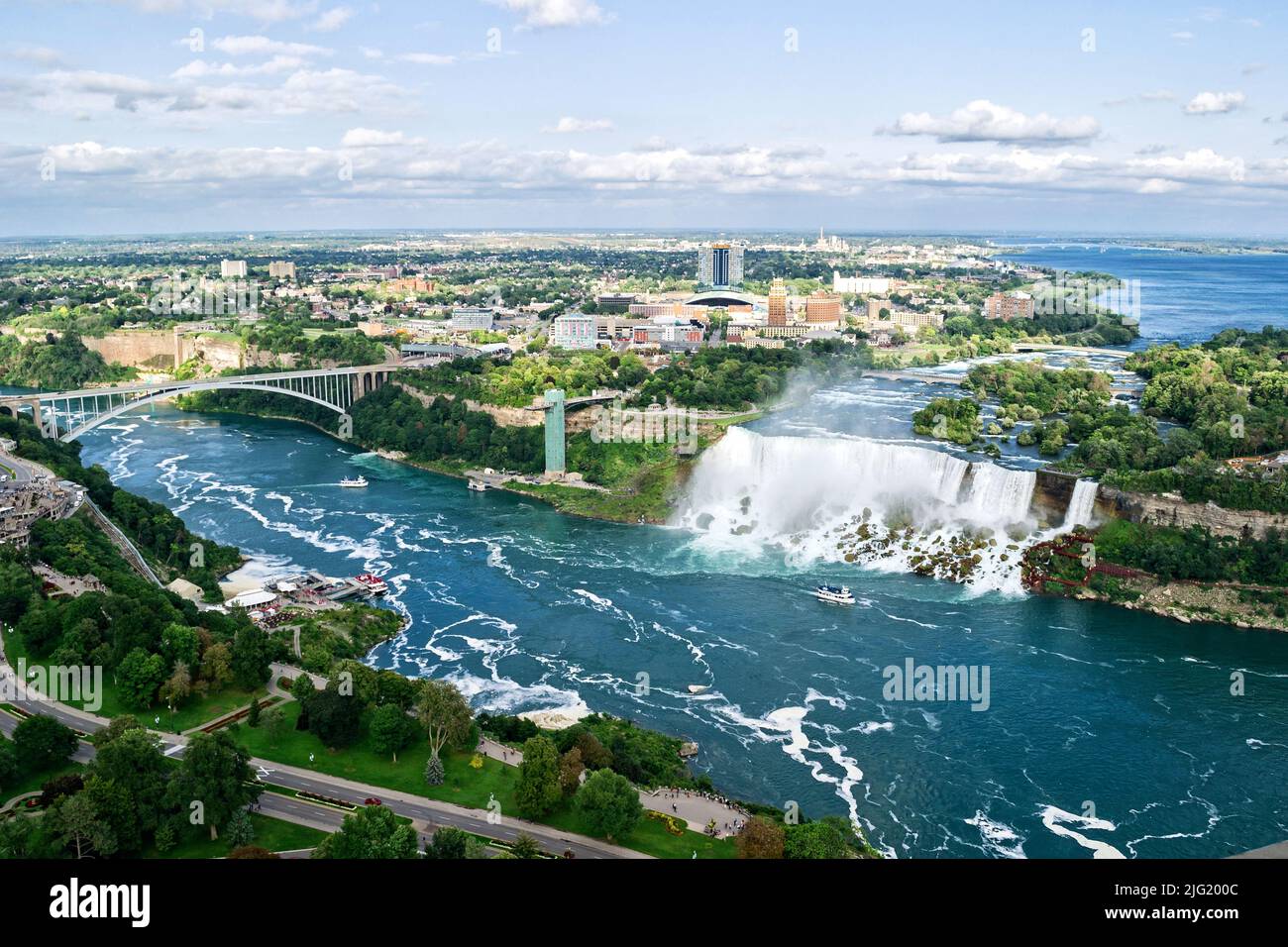 Vue panoramique des chutes du Niagara dans la journée sur la rivière avec rochers et bateau. Banque D'Images