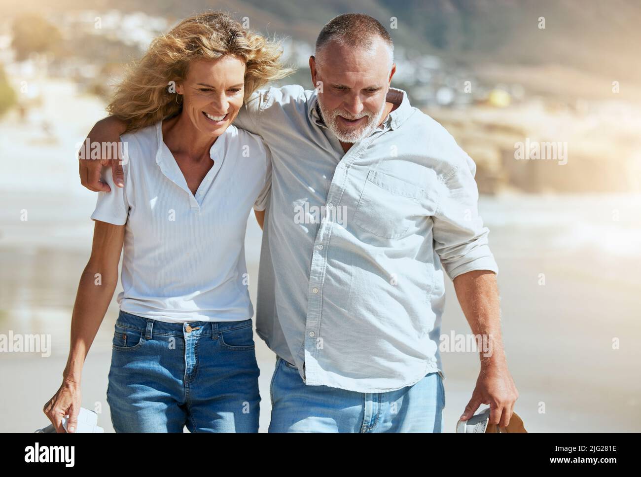 Couple d'âge mûr souriant s'embrassant et marchant pendant des vacances à la plage outre-mer. Mari et femme heureux profitant de temps libre et de vacances. Homme et femme Banque D'Images