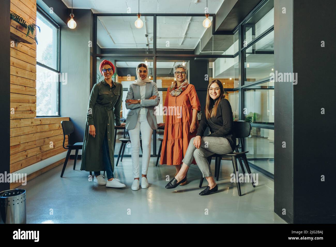 Groupe de femmes d'affaires qui ont réussi à sourire à la caméra dans un bureau. Équipe d'entrepreneurs multiculturels travaillant ensemble dans un milieu de travail inclusif. Banque D'Images
