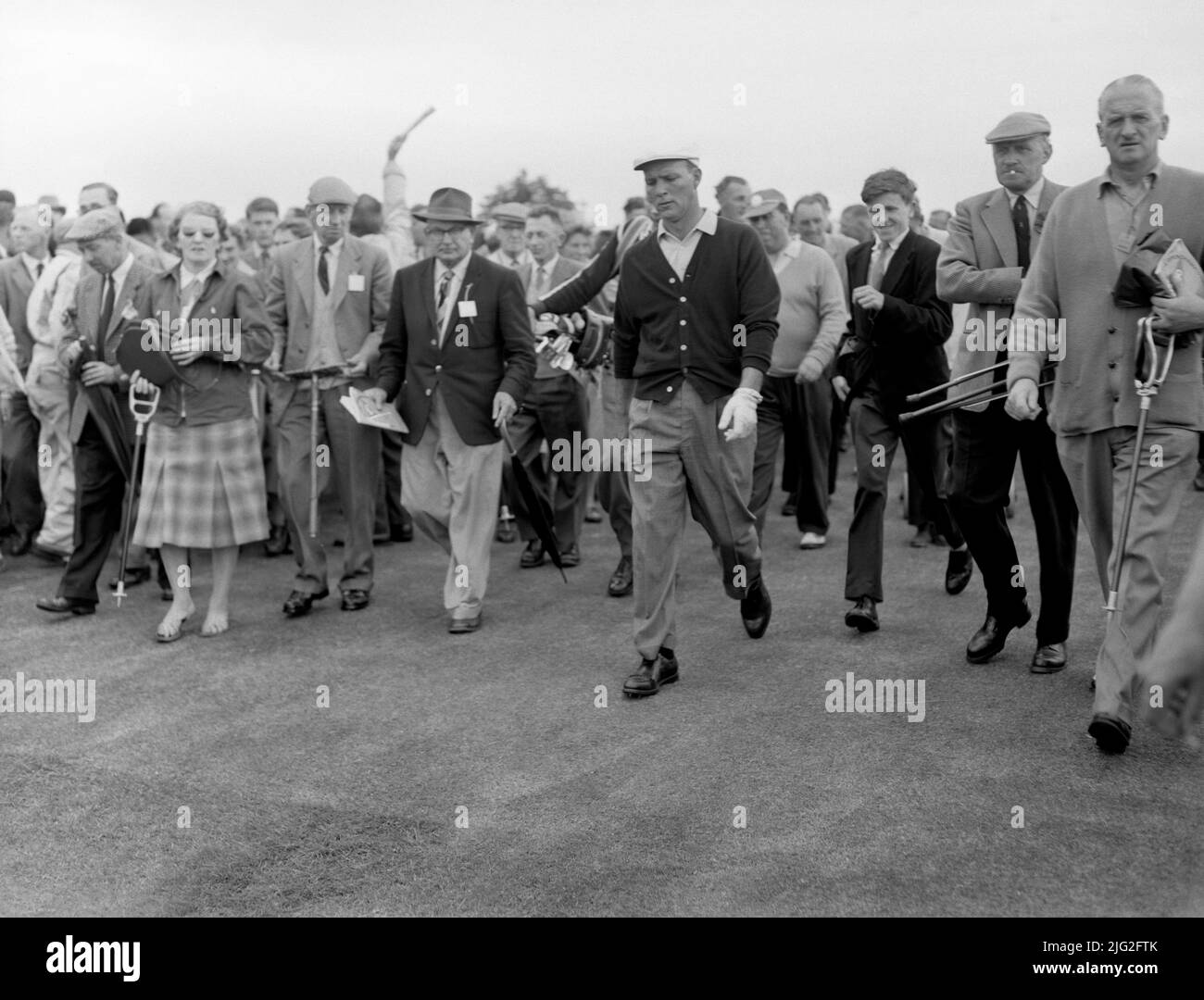 Photo du dossier datée du 5-07-1960 d'Arnold Palmer, le golfeur américain, suivi de sa galerie à St.Andrews, Fife, Écosse. Arnold Palmer a fait ses débuts très attendus en 1960 en ayant déjà remporté les Masters et l'US Open cette année-là, mais a dû passer par un qualificatif de 36 trous pour prendre sa place sur le terrain. La participation de Palmer a insufflé une nouvelle vie à un championnat qui avait manqué de stars américaines et bien qu'il ait battu le niveau des trois premiers jours et fermé avec un 68, l'australien Kel Nagle l'a battu par un. Date de publication : jeudi 7 juillet 2022. Banque D'Images