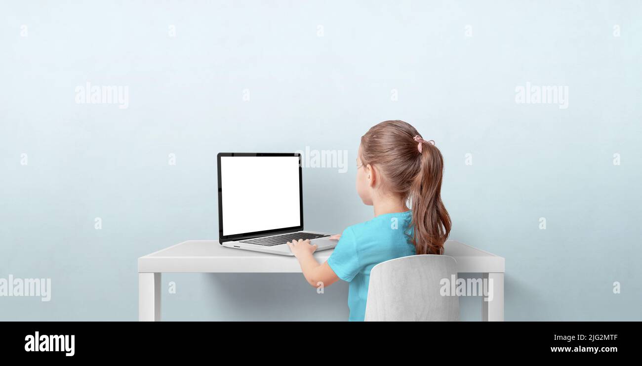 Jeune fille utilisant un ordinateur portable dans la salle de séjour. Écran d'ordinateur portable isolé pour la promotion des pages Web. Vue arrière. Copier l'espace sur le mur Banque D'Images