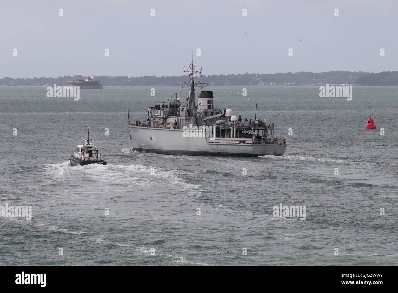 Le HMS BROCKLESBY change de cap lorsqu'il quitte le port et se dirige vers le Solent, accompagné d'un pilote d'amirauté Banque D'Images