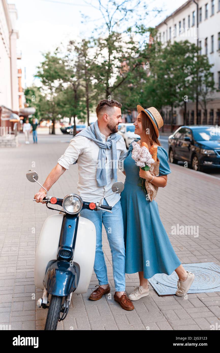 Happy young couple riding a scooter dans la ville sur une journée ensoleillée Banque D'Images