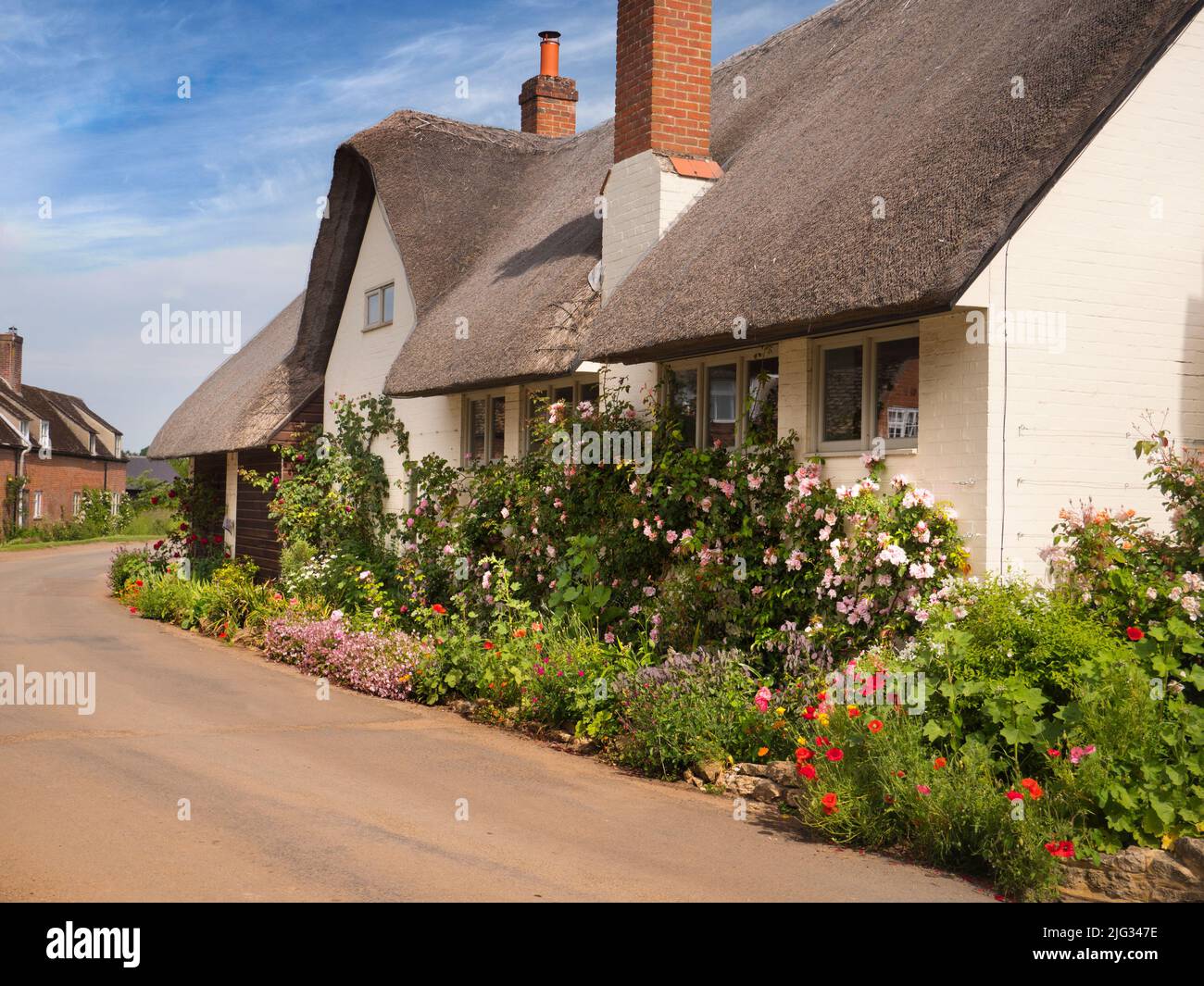 Un magnifique cottage au chaume dans le village de Lower Radley, un beau matin d'été. Mais attention, tout n'est pas aussi idyllique qu'il pourrait paraître. Le Banque D'Images