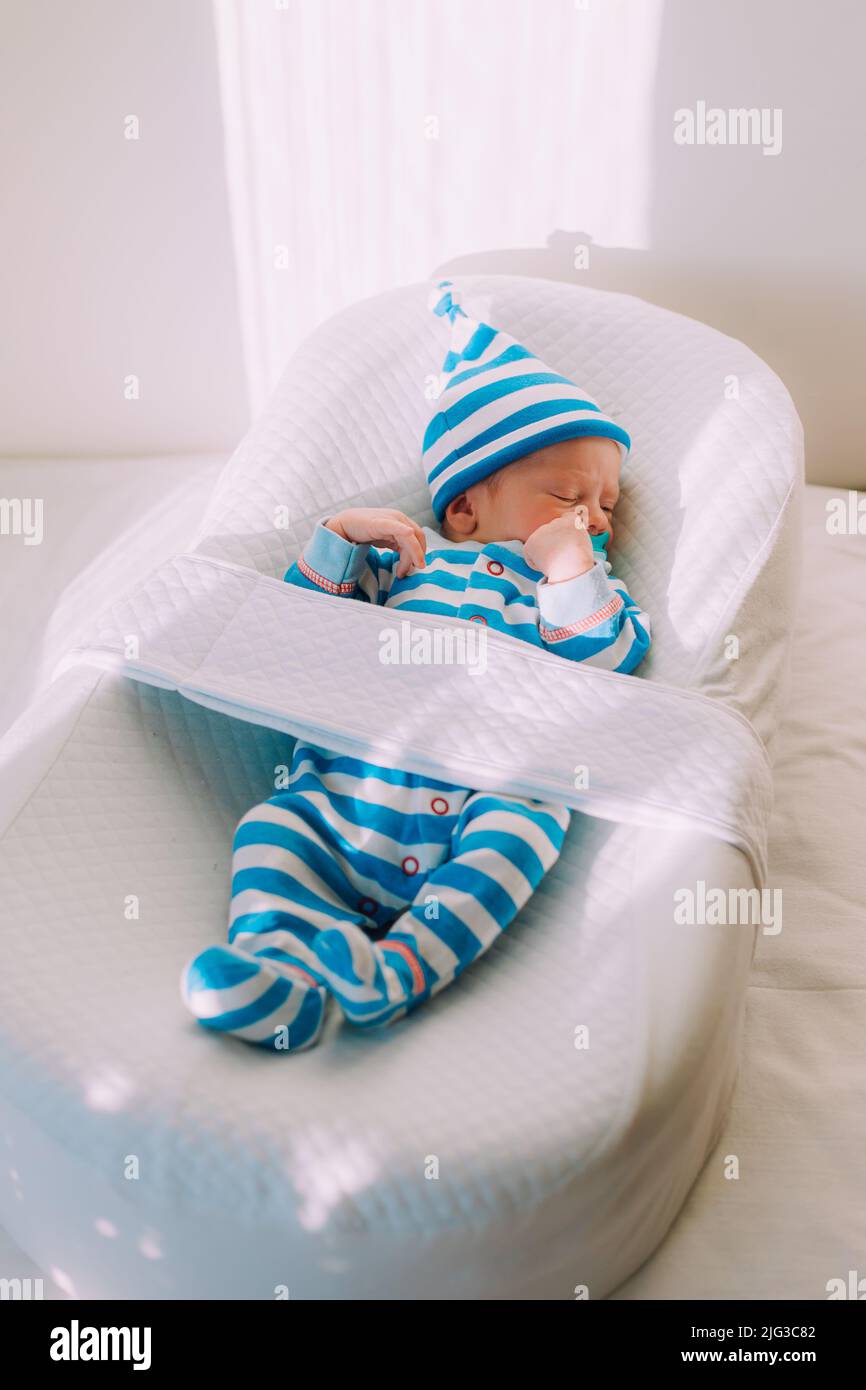 Le bébé est allongé dans un cocon d'espace de copie . Le bébé a 0-3 mois. Un bébé content. Un article sur le choix d'un cocon pour les nouveau-nés. Un arti Banque D'Images