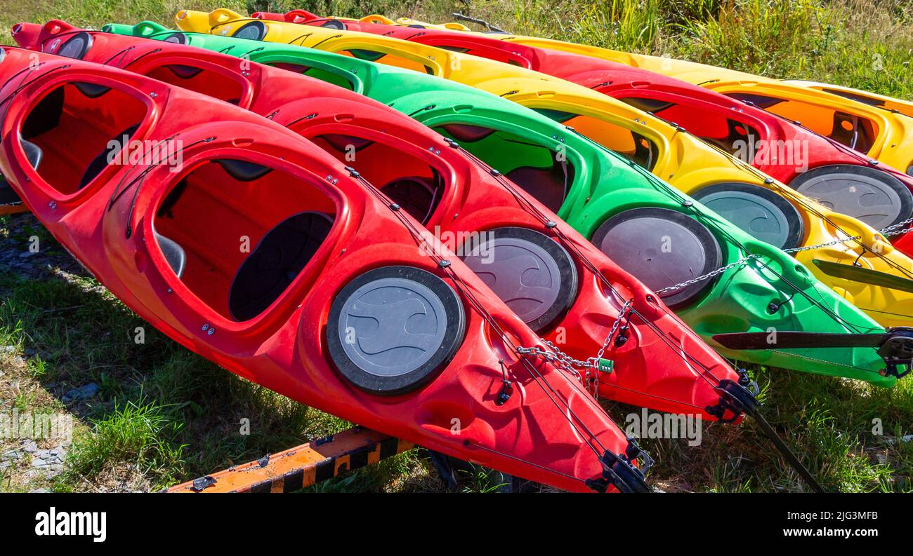 Kayaks rouges, jaunes, verts tirés dans une file Banque D'Images