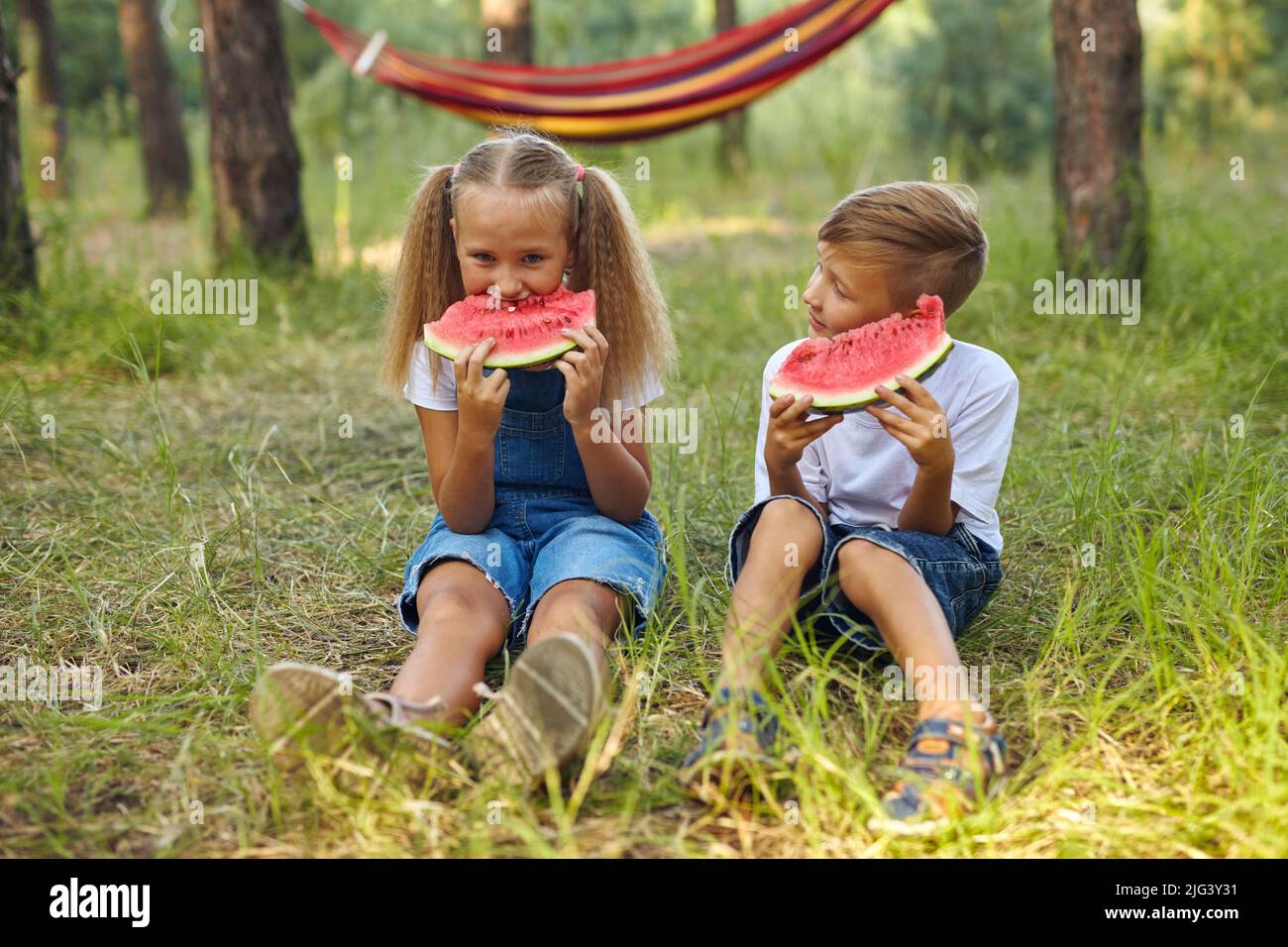Les enfants adorables mangent de la pastèque dans le jardin. Banque D'Images