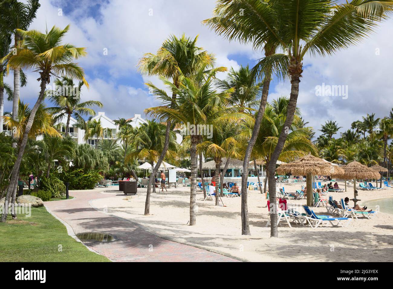 ORANJESTAD, ARUBA - 4 DÉCEMBRE 2021 : piscine et plage de sable de l'hôtel Renaissance Ocean Suites avec palmiers et chaises de plage Banque D'Images