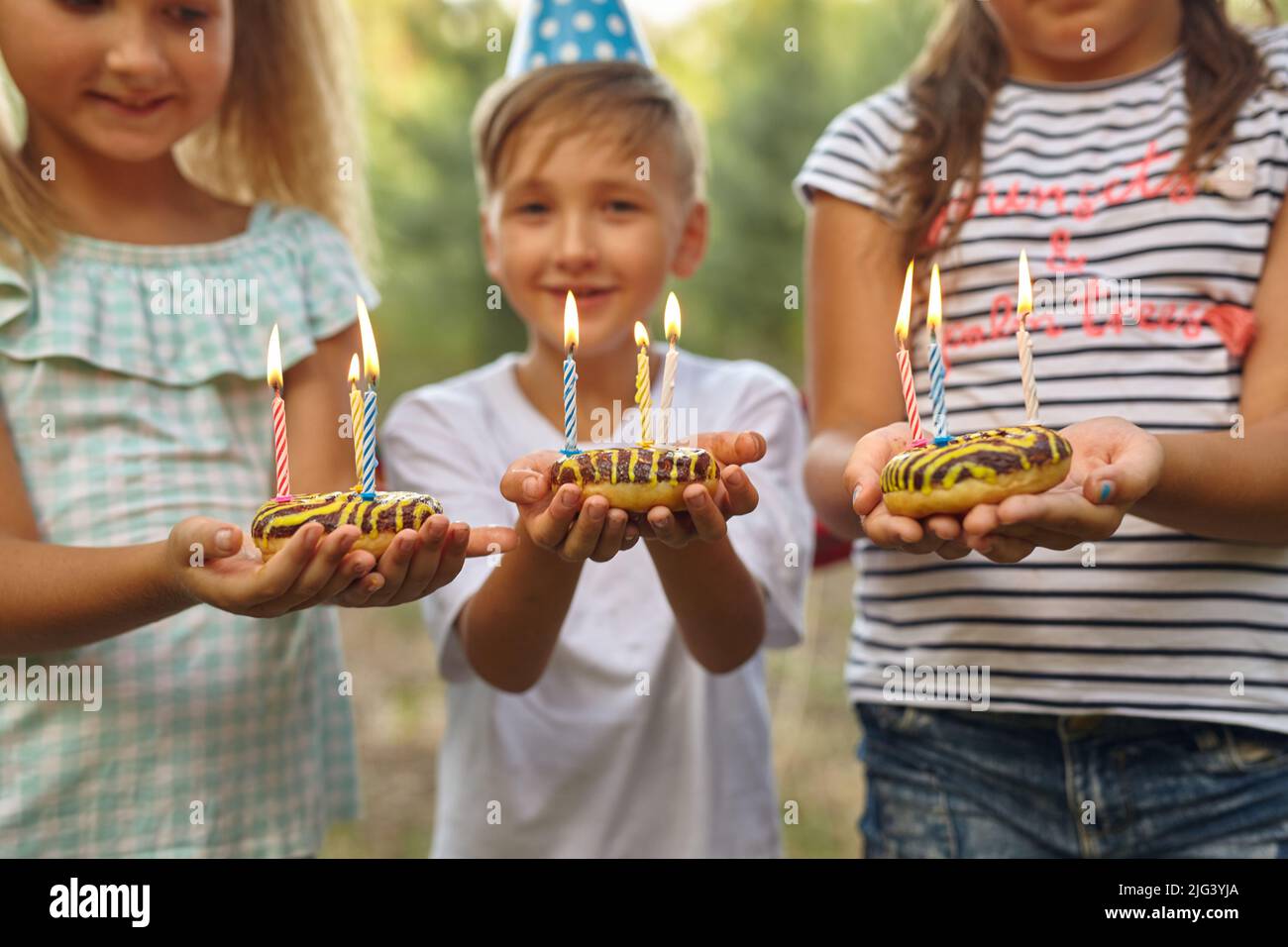 Garçon et fille fêtant leur anniversaire en plein air dans le jardin Banque D'Images