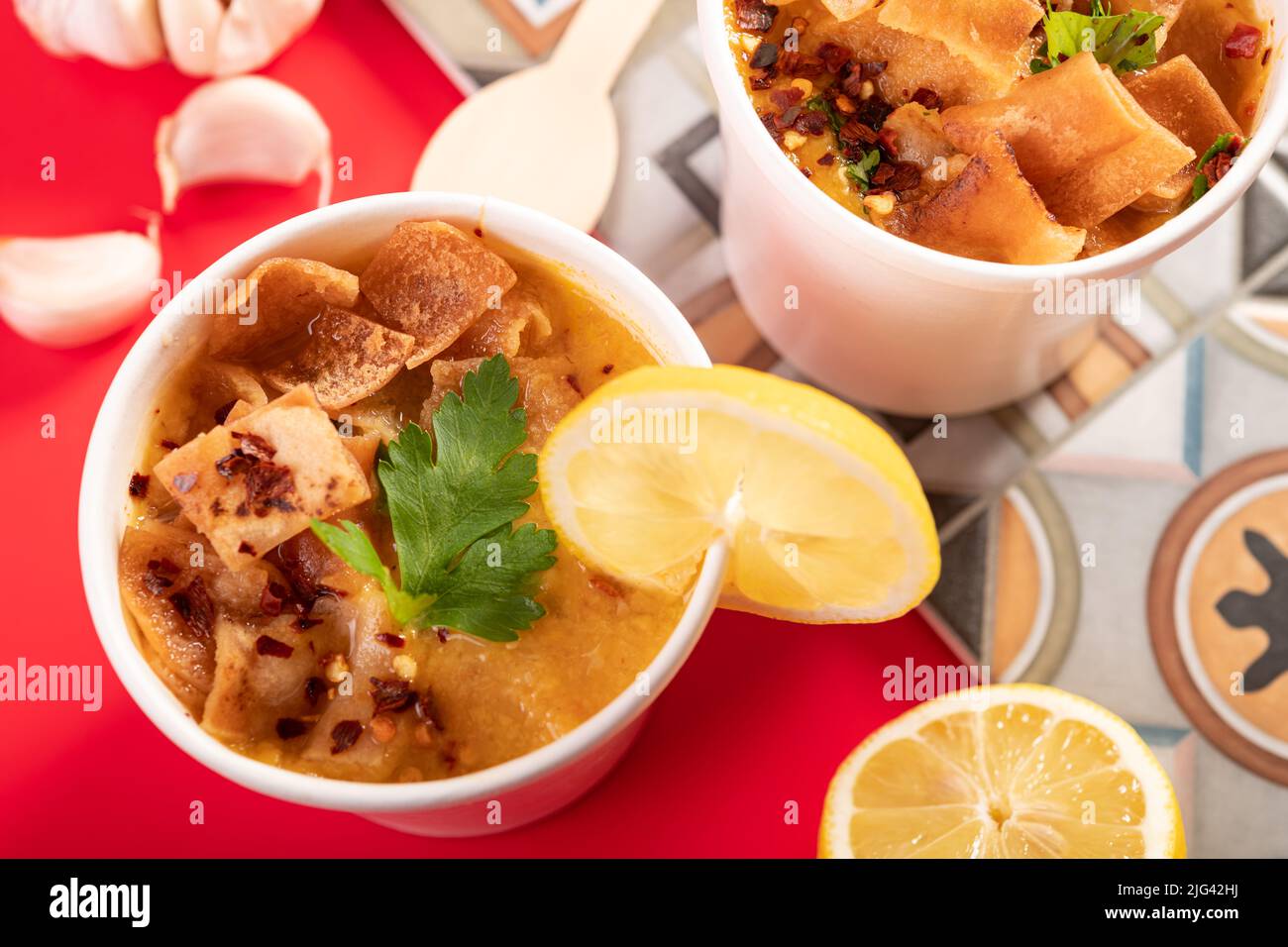 Soupe marocaine traditionnelle méditerranéenne aux lentilles, garnie de pain plat, de piment et de coriandre à emporter Banque D'Images