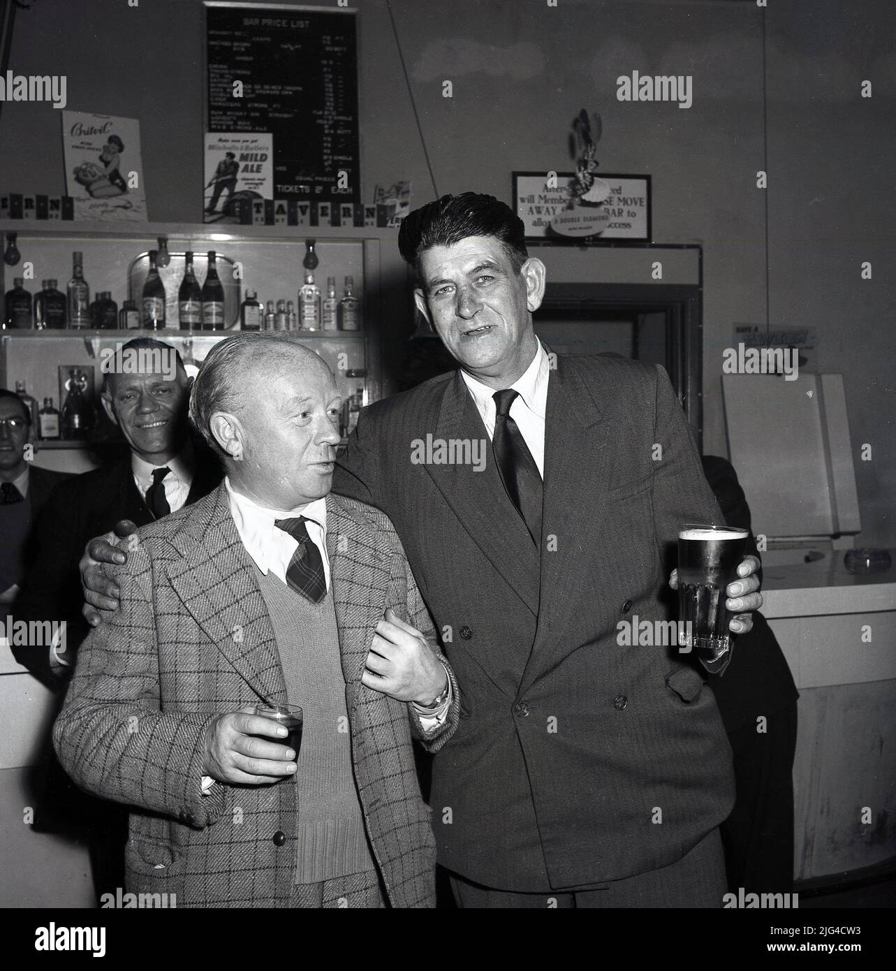 1950s, historique, deux ouvriers en acier bien habillés en chemise et cravates ayant un verre après une journée de travail dans le bar de l'entreprise, à la Compagnie de l'acier du pays de Galles, Abbey Works, Port Talbot, bar du personnel Banque D'Images