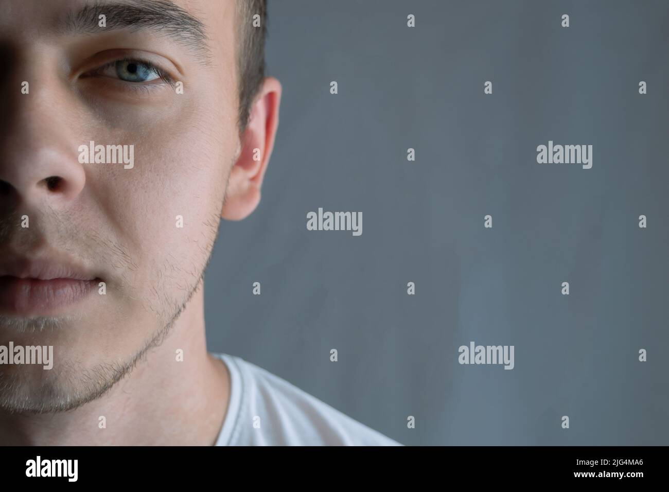 Portrait d'un beau jeune homme aux yeux bleus, demi-visage, espace pour le texte Banque D'Images