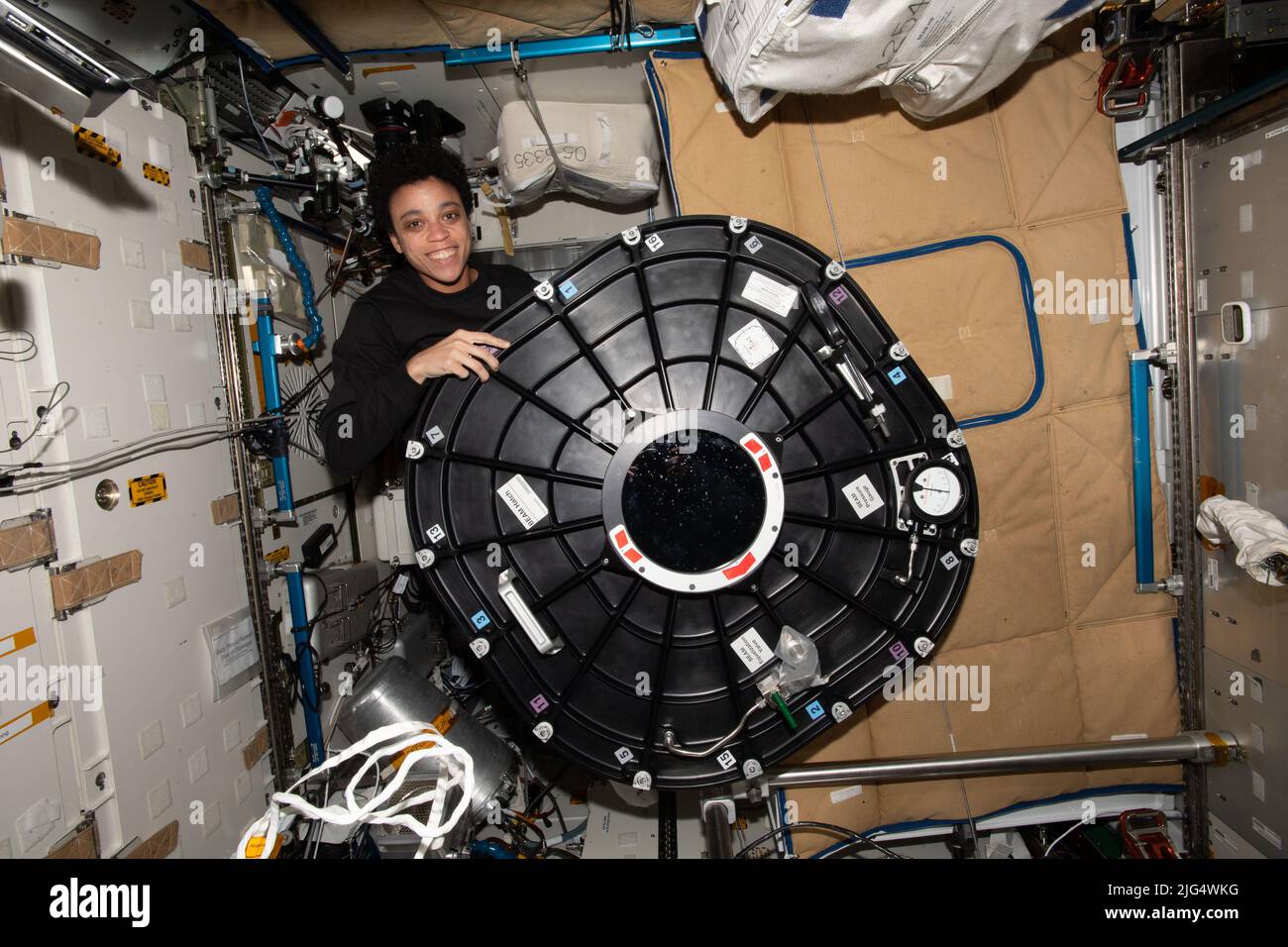 Jessica Watkins, ingénieure de vol de l'expédition 67 de la NASA, pose avec la couverture de la trappe du module d'activité extensible Bigelow à l'intérieur du module tranquillité à bord de la Station spatiale internationale, 10 juin 2022 dans l'orbite de la Terre. Banque D'Images