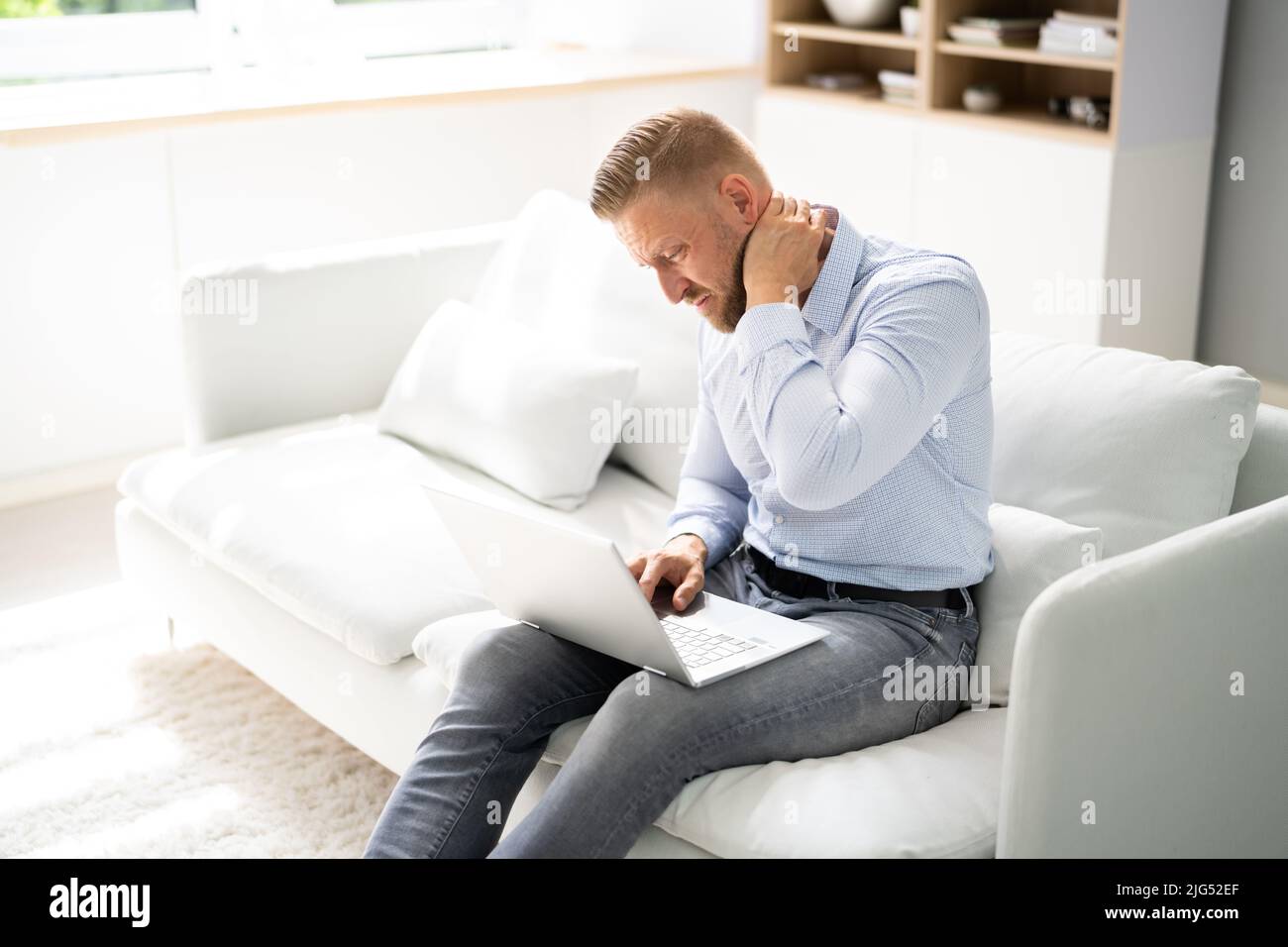 Douleur au cou mauvaise posture Homme assis à la maison Banque D'Images