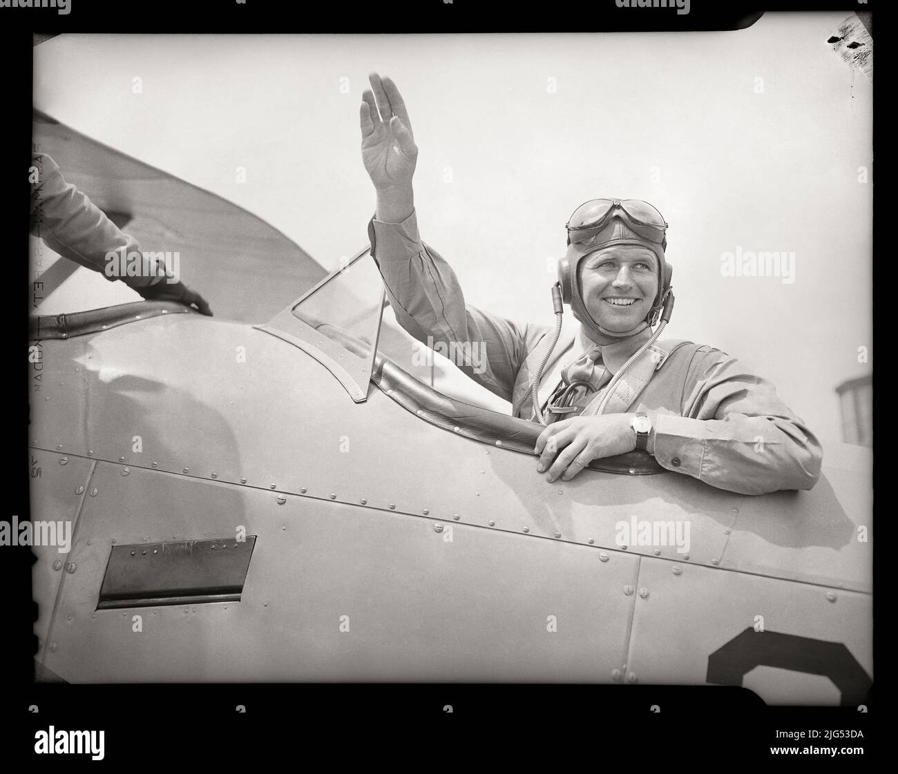 Le Naval Aviator, Joseph “Joe” Kennedy Jr., fait des vagues depuis le cockpit de l'avion. Juillet 1941. Naval Air Station Squantum, Massachusetts, États-Unis. Image de négatif 4 x 5 pouces. Banque D'Images