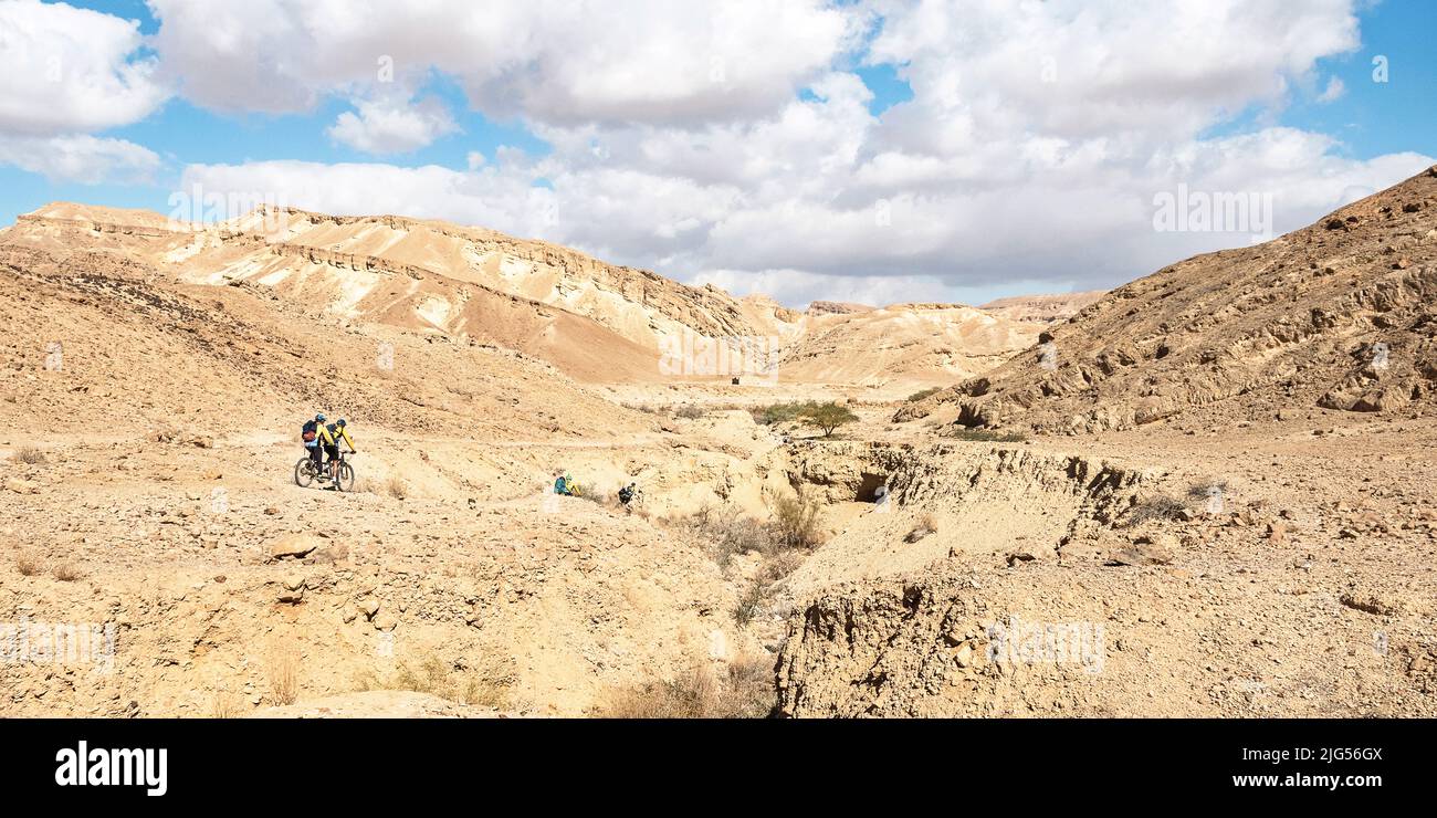 mountain cycleurs sur des vélos tandem près de l'ancienne forteresse Nabatean Nekarot sur la route des épices Encens dans le Negev en Israël sous un ciel partiellement nuageux Banque D'Images