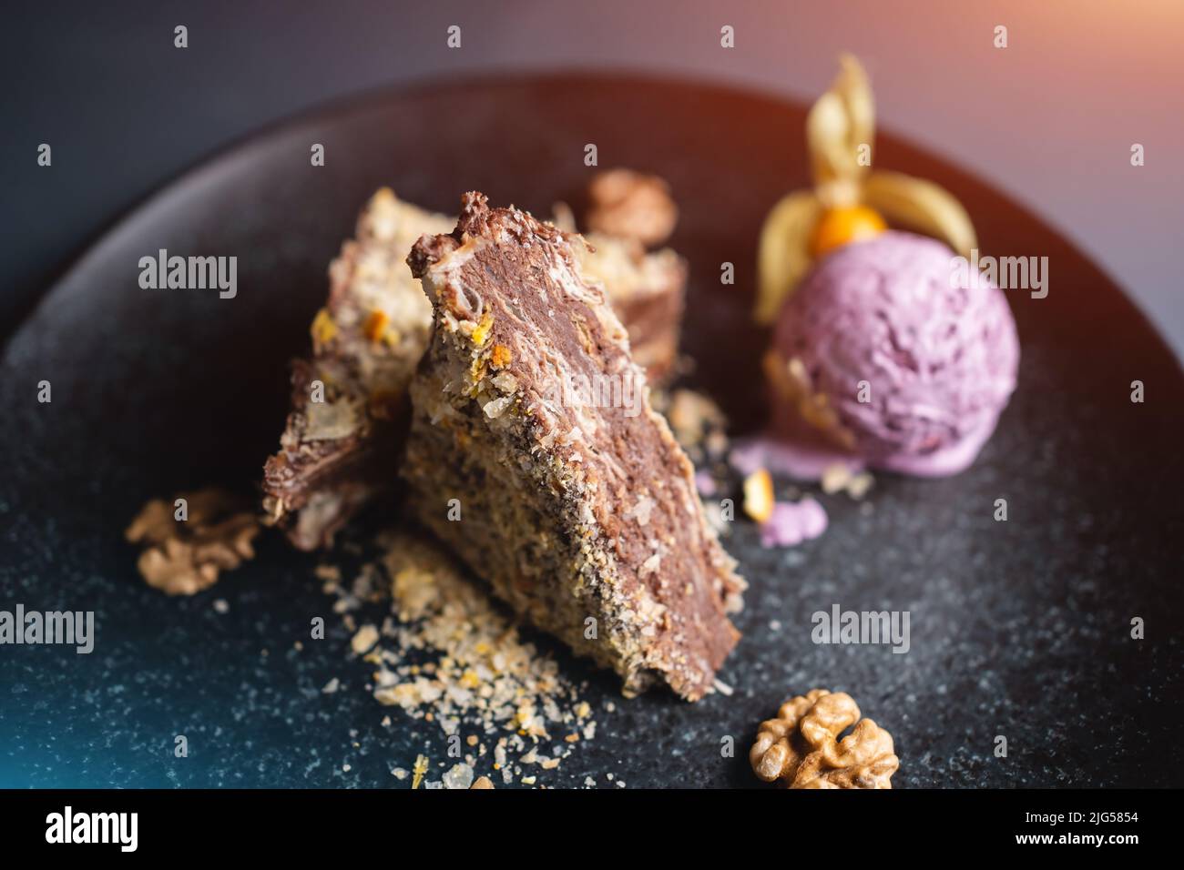 gâteau à pâte feuilletée avec crème glacée au chocolat, aux noix et aux myrtilles sur une assiette noire Banque D'Images