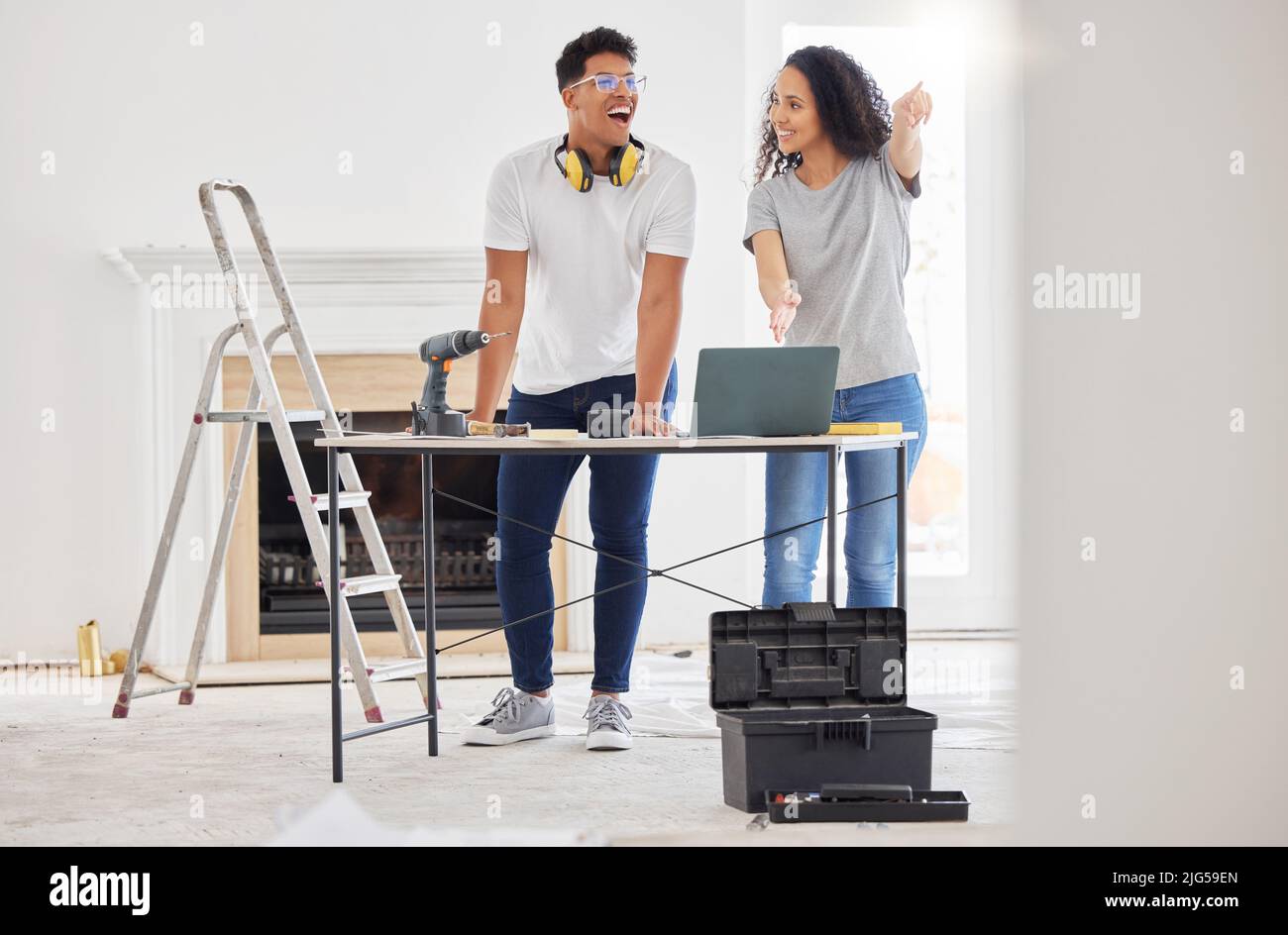 La rénovation d'une maison est un pas de cerveau pour les gens qui aiment un défi. Photo d'un jeune couple utilisant un ordinateur portable tout en étant occupé à rénover une maison. Banque D'Images