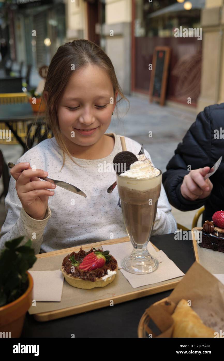 une fille avec un milkshake et un gâteau Banque D'Images