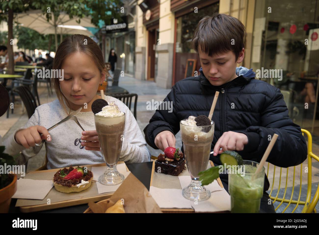 un garçon et une fille avec un milkshake et un gâteau Banque D'Images