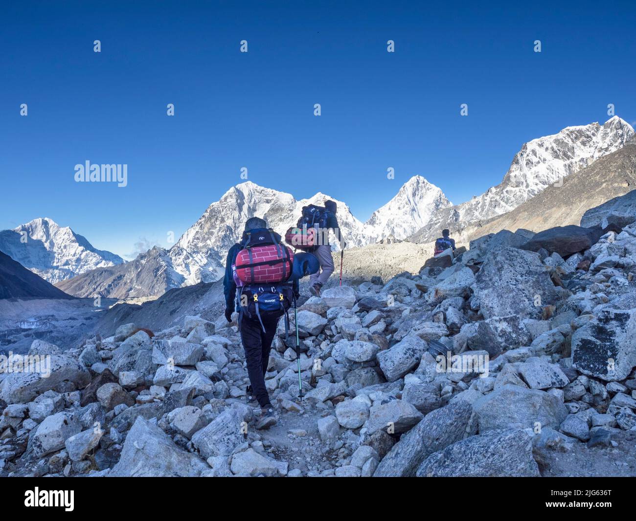 Ttekkers traversant la moraine jusqu'à Lobuche de Gorak Shep un matin clair de mai après le retour de l'Everest base Camp, Khumbu. Banque D'Images