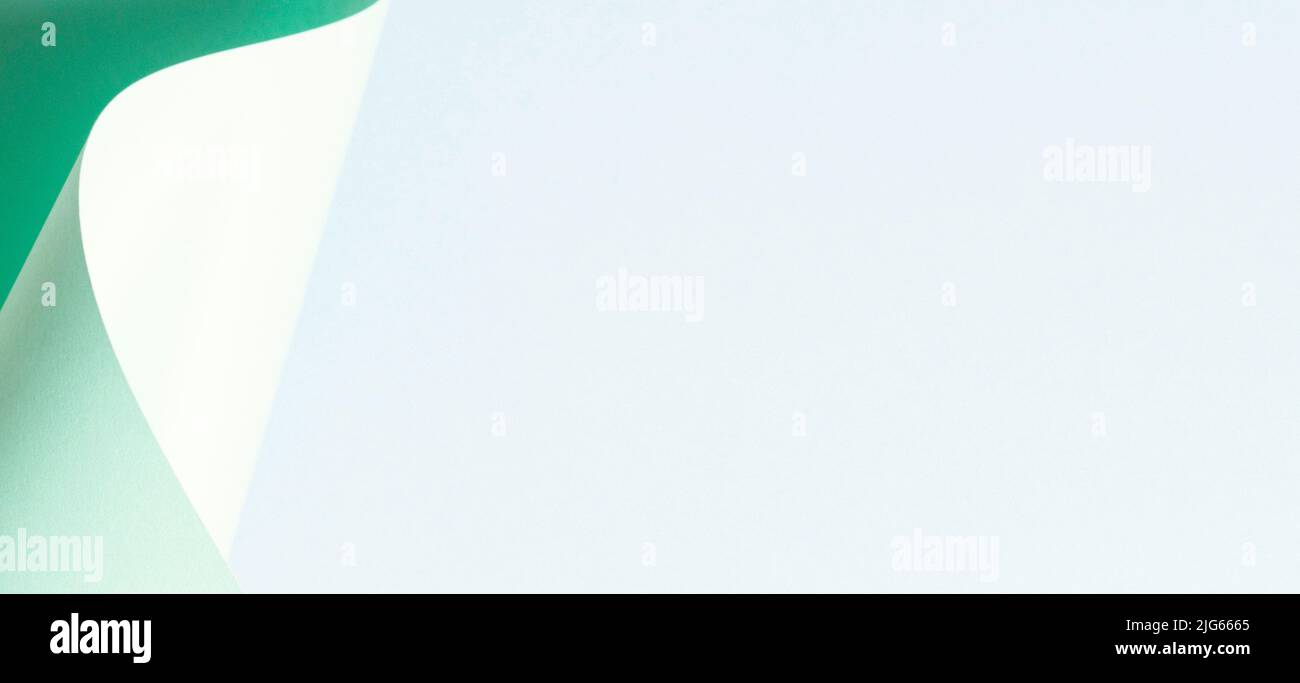 Vague abstraite de papier vert pastel sur fond bleu clair. Papier courbe géométrique créatif avec lumière et ombres. Arrière-plan de la géométrie abstraite Banque D'Images