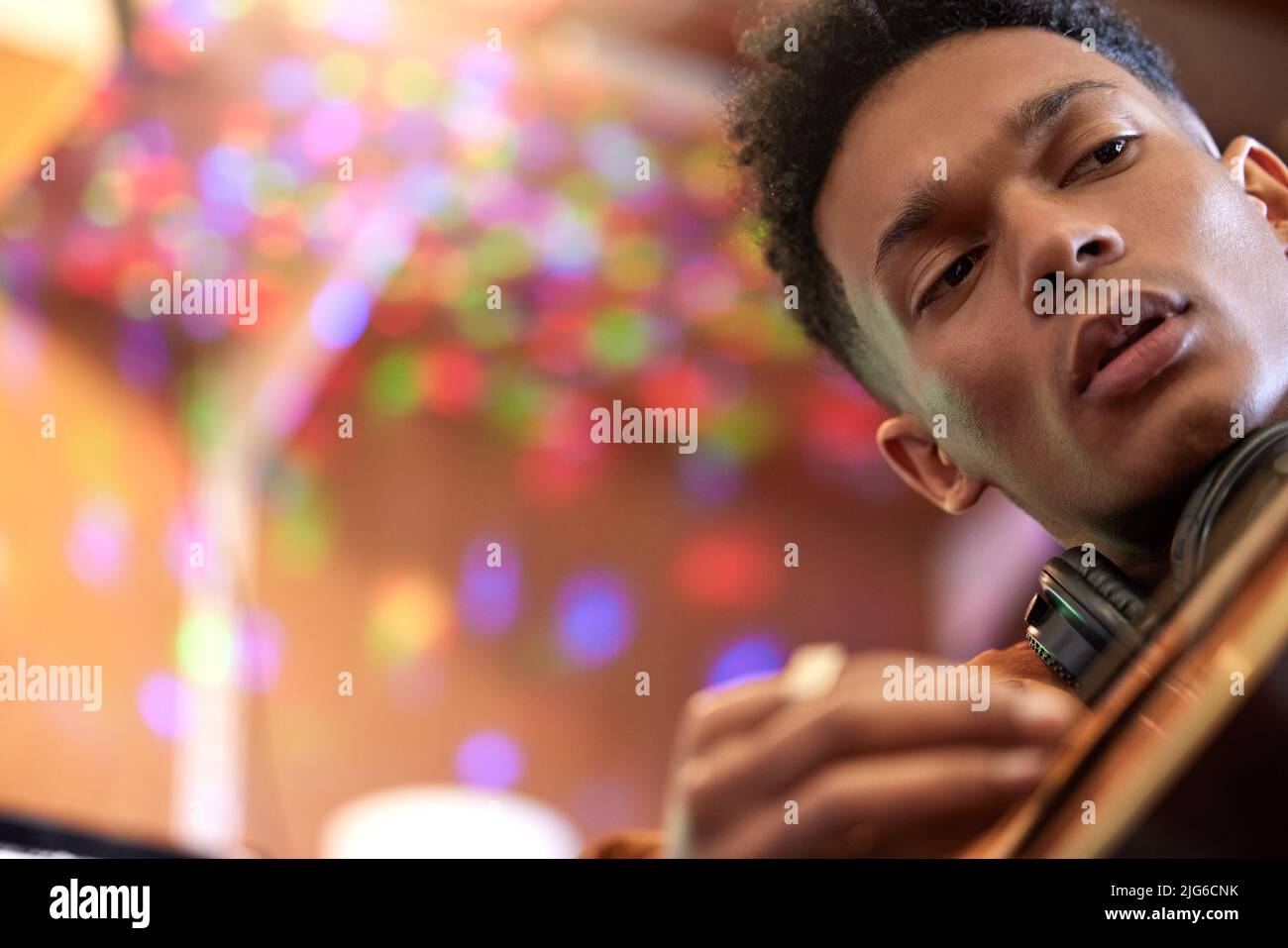 Chaque corde a son propre son unique. Plan court d'un beau jeune musicien masculin jouant sa guitare à la maison. Banque D'Images