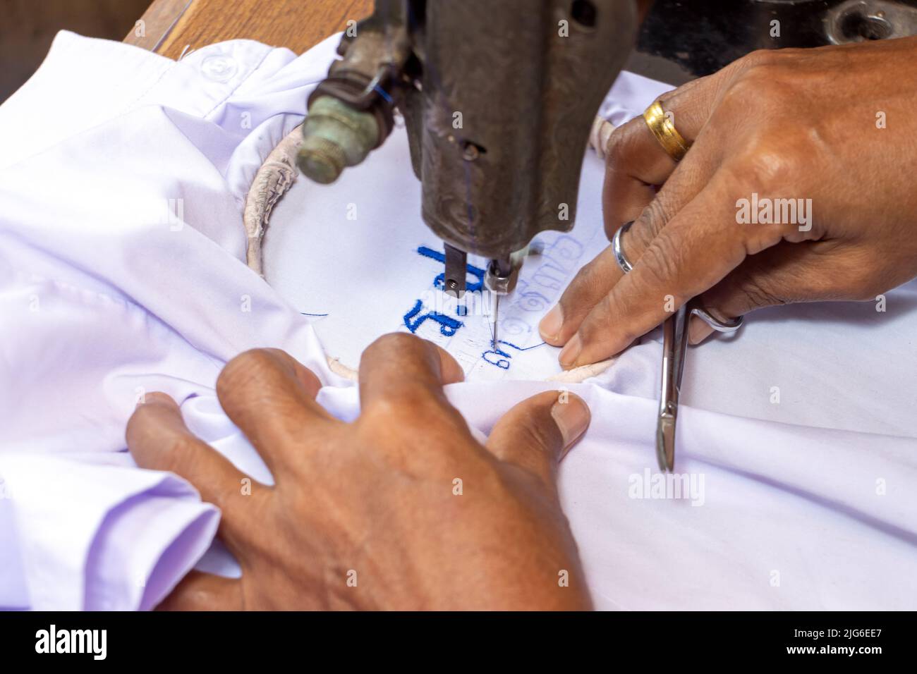 Broder des numéros thaïlandais sur une chemise d'étudiant sur une vieille machine à coudre Banque D'Images