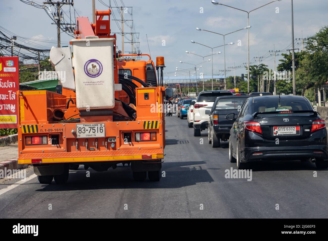 THAÏLANDE, JUIN 11 2022, un convoi de voitures, y compris un camion avec une plate-forme de levage, se déplace lentement dans la rue de la ville Banque D'Images