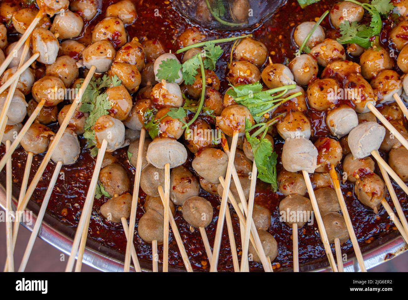 Un meatballs sur un bâton dans un bol avec de la sauce chaude, gros plan Banque D'Images