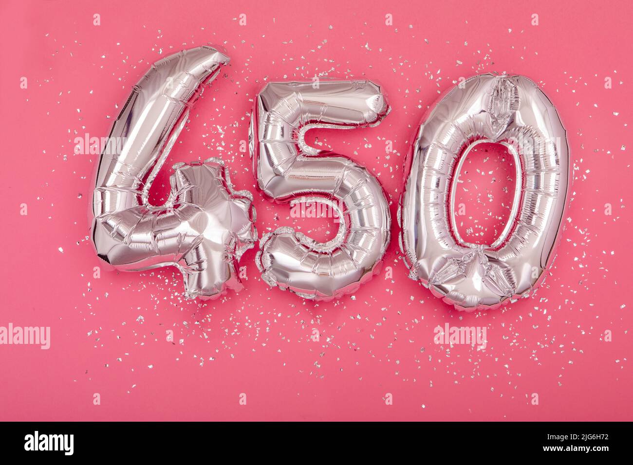 Ballon d'argent montrant le numéro 450 quatre cent cinquante fond rose Banque D'Images