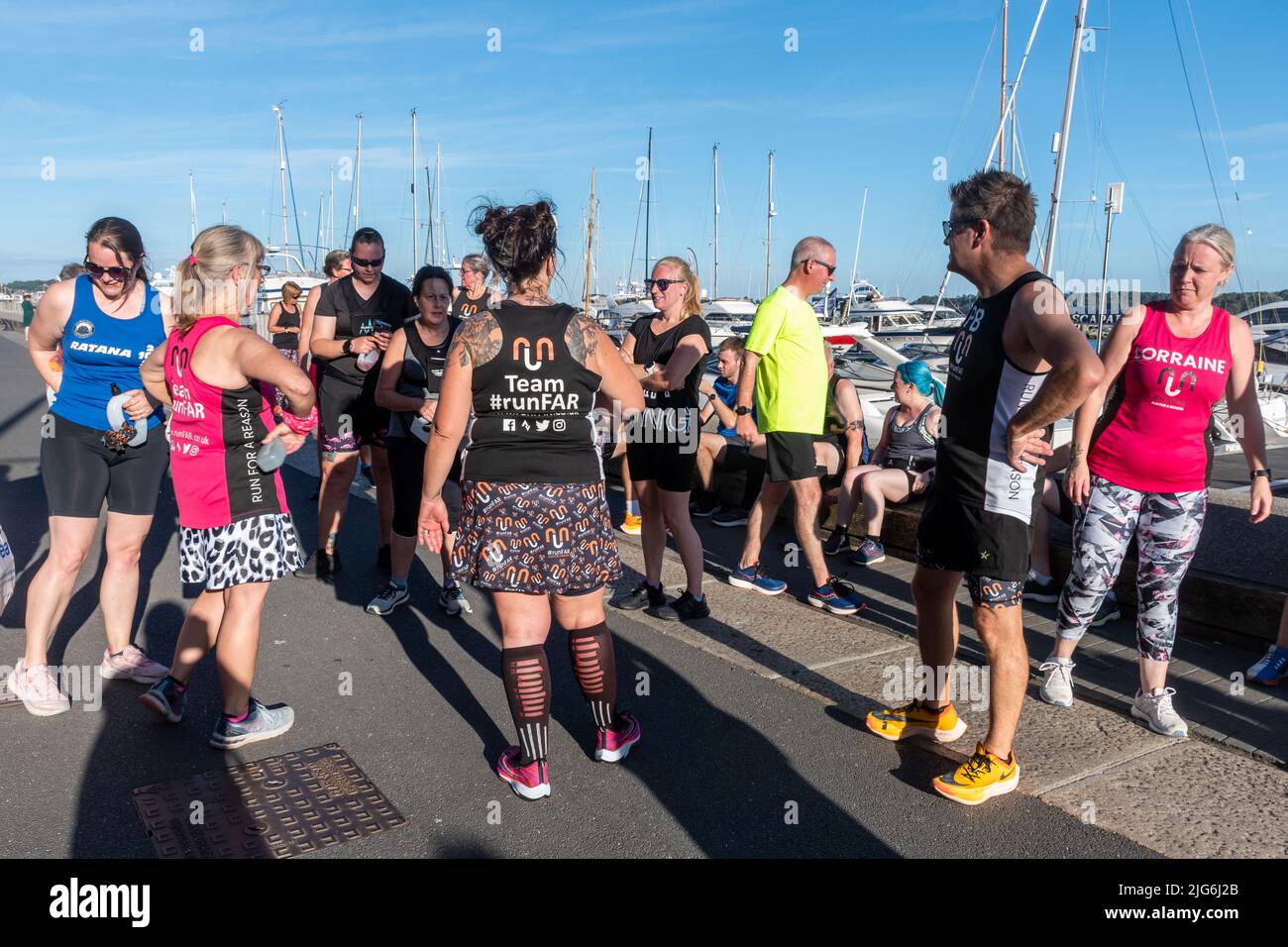 Un groupe de coureurs de l'équipe RunFar se sont rassemblés après une course sur le front de mer de Poole, Dorset, Angleterre, Royaume-Uni Banque D'Images