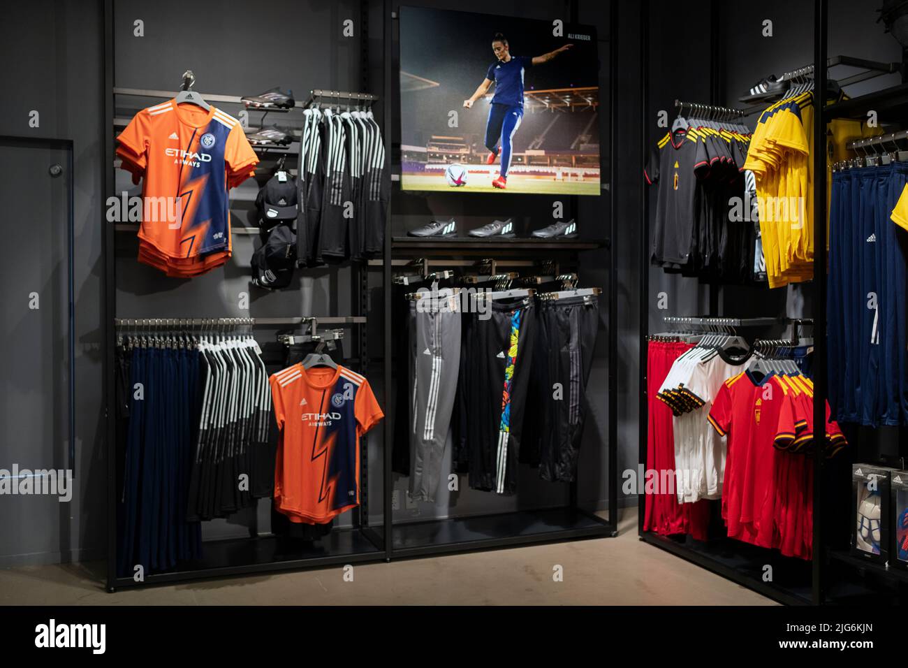 Vêtements de football pour femmes en vente au magasin adidas de Broadway, dans le Lower manhattan, New York. Comprend des maillots colorés et une grande photo d'Ali Kreiger. Banque D'Images