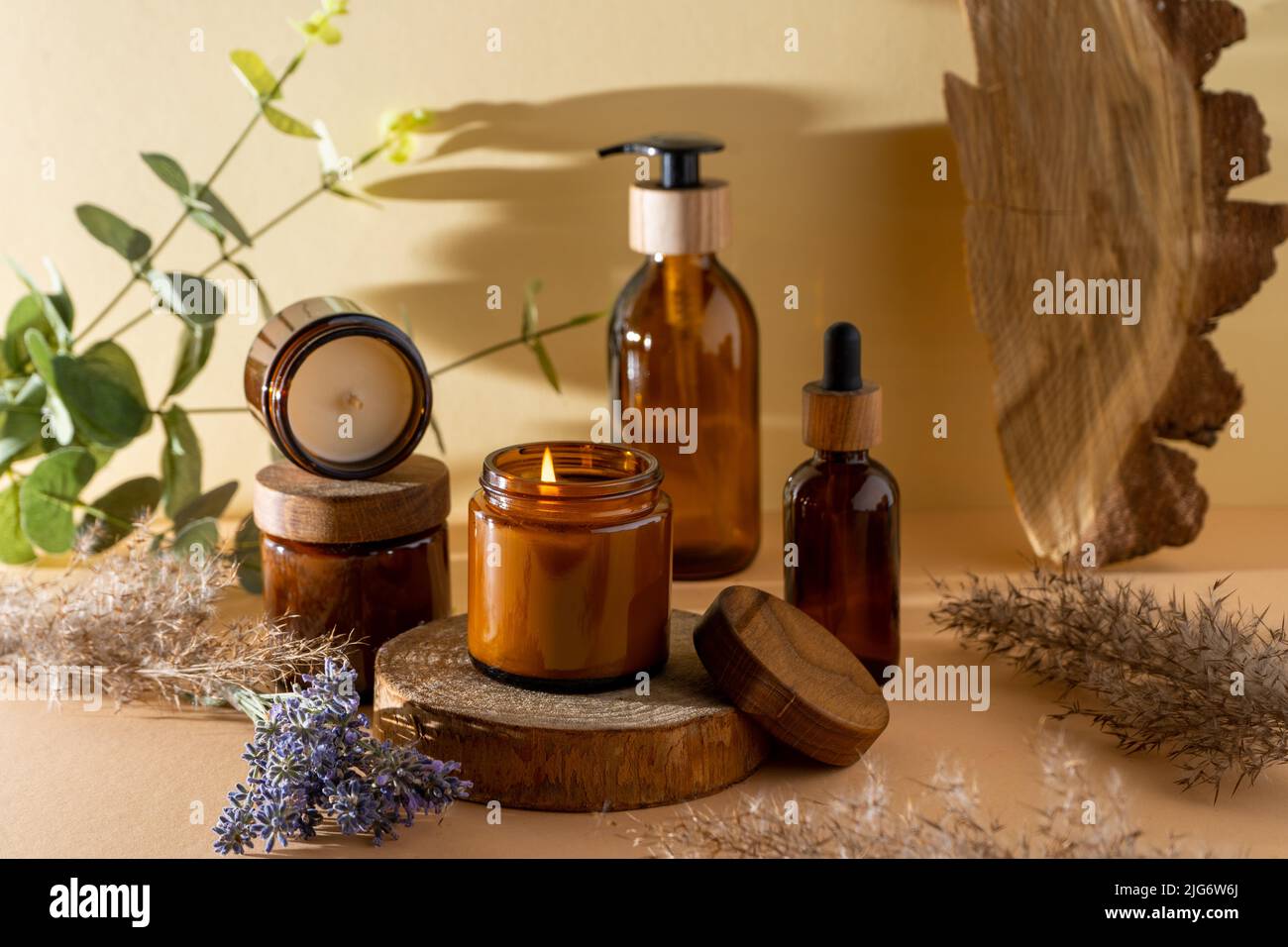 Bougies de soja dans un pot en verre. Aromathérapie. Bougie brûlante et lavande. Couvercle en bois pour bocaux. Arrière-plan beige. Confort et détente. Fait à la main. Décoration d'intérieur. Banque D'Images