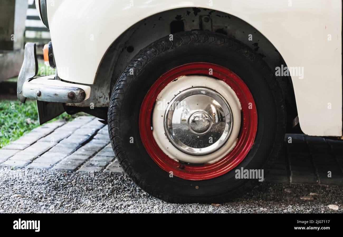 Photo en gros plan de la roue rouge blanche d'une voiture garée sur une route Banque D'Images