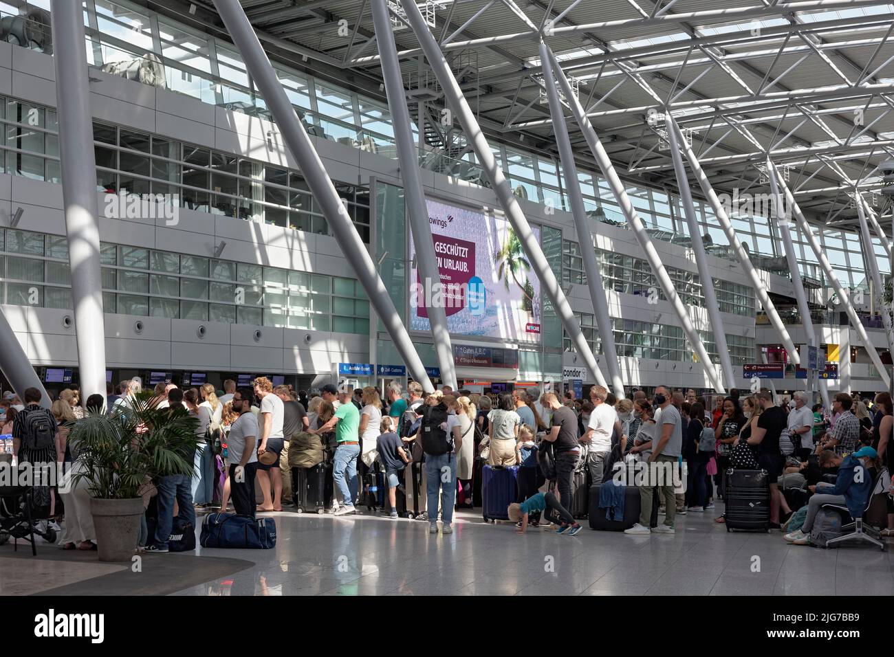 Les passagers attendant l'enregistrement devant le comptoir d'enregistrement font la queue pendant les vacances d'été, à l'aéroport de Düsseldorf, en Rhénanie-du-Nord-Westphalie Banque D'Images
