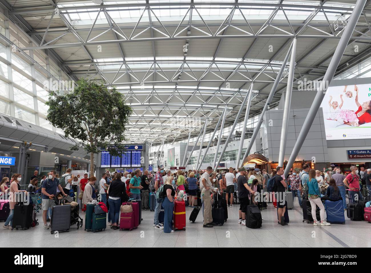 Les passagers attendant l'enregistrement devant le comptoir d'enregistrement font la queue pendant les vacances d'été, à l'aéroport de Düsseldorf, à Düsseldorf, au nord Banque D'Images