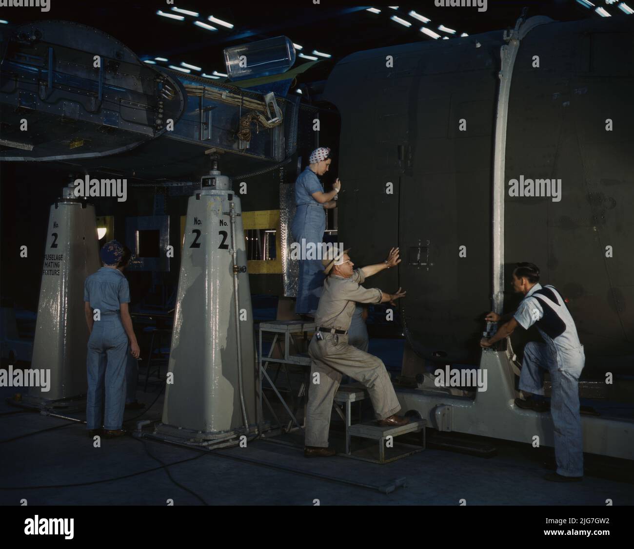 Mise en place de la partie nez d'un puissant avion de transport dans le dispositif d'accouplement du fuselage à l'usine de Consolidated Aircraft Corporation, fort Worth, Texas. Banque D'Images