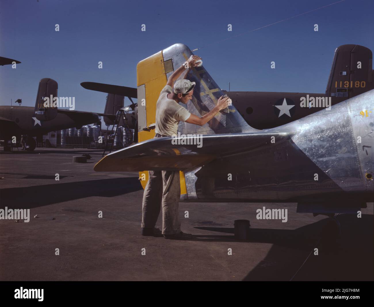 Sur la ligne de montage extérieure de l'Amérique du Nord, un peintre nettoie la section de queue d'un chasseur P-51 avant de pulvériser le camouflage vert olive de l'armée américaine, North American Aviation, Inc., Inglewood, Calif. Banque D'Images