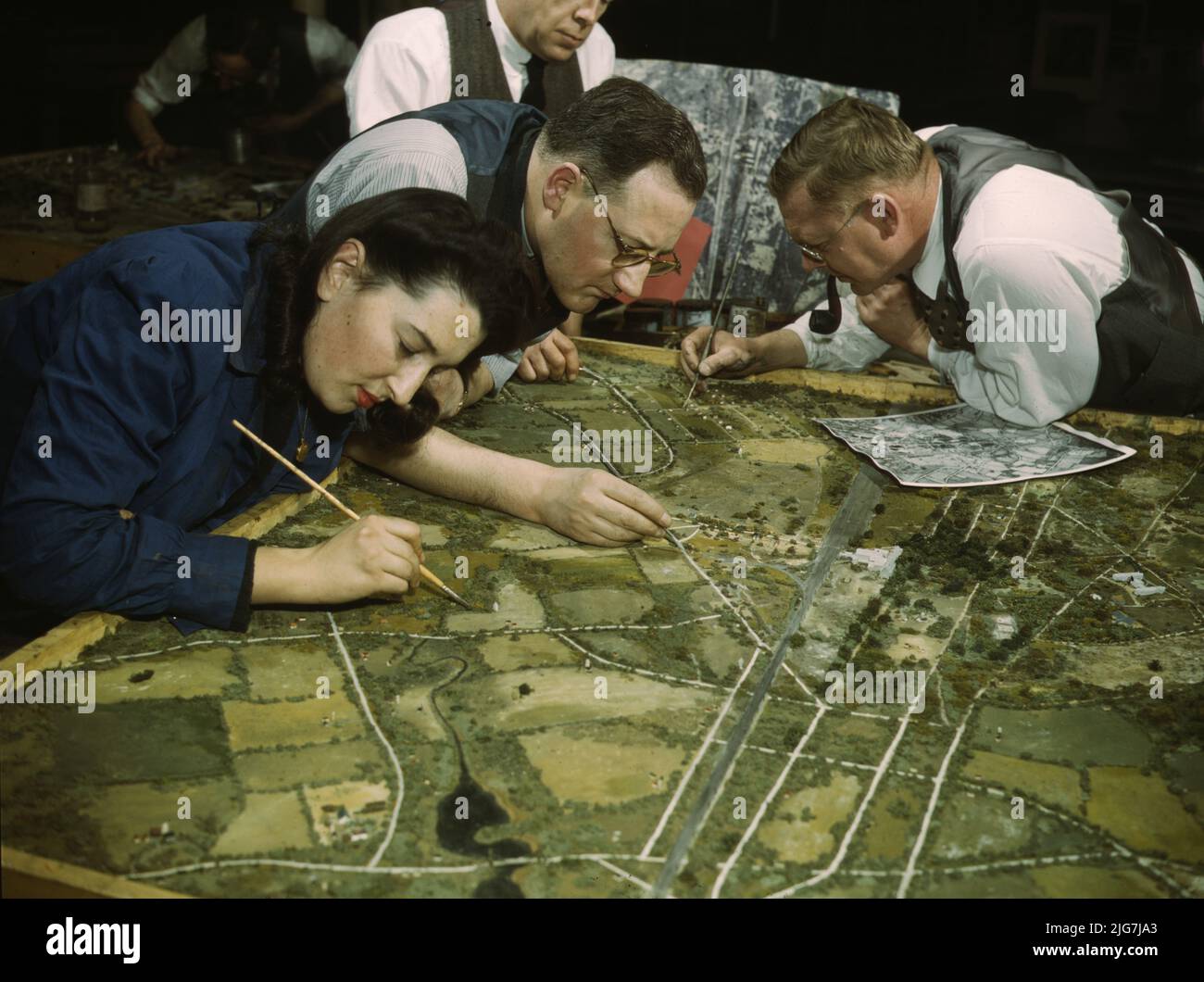 Classe de camouflage à l'Université de New York, où les hommes et les femmes se préparent pour des emplois dans l'Armée ou dans l'industrie, New York, N.Y., ils font des modèles à partir de photographies aériennes, les rephotographient, puis ils élaborent un schéma de camouflage et font une photographie finale. Banque D'Images