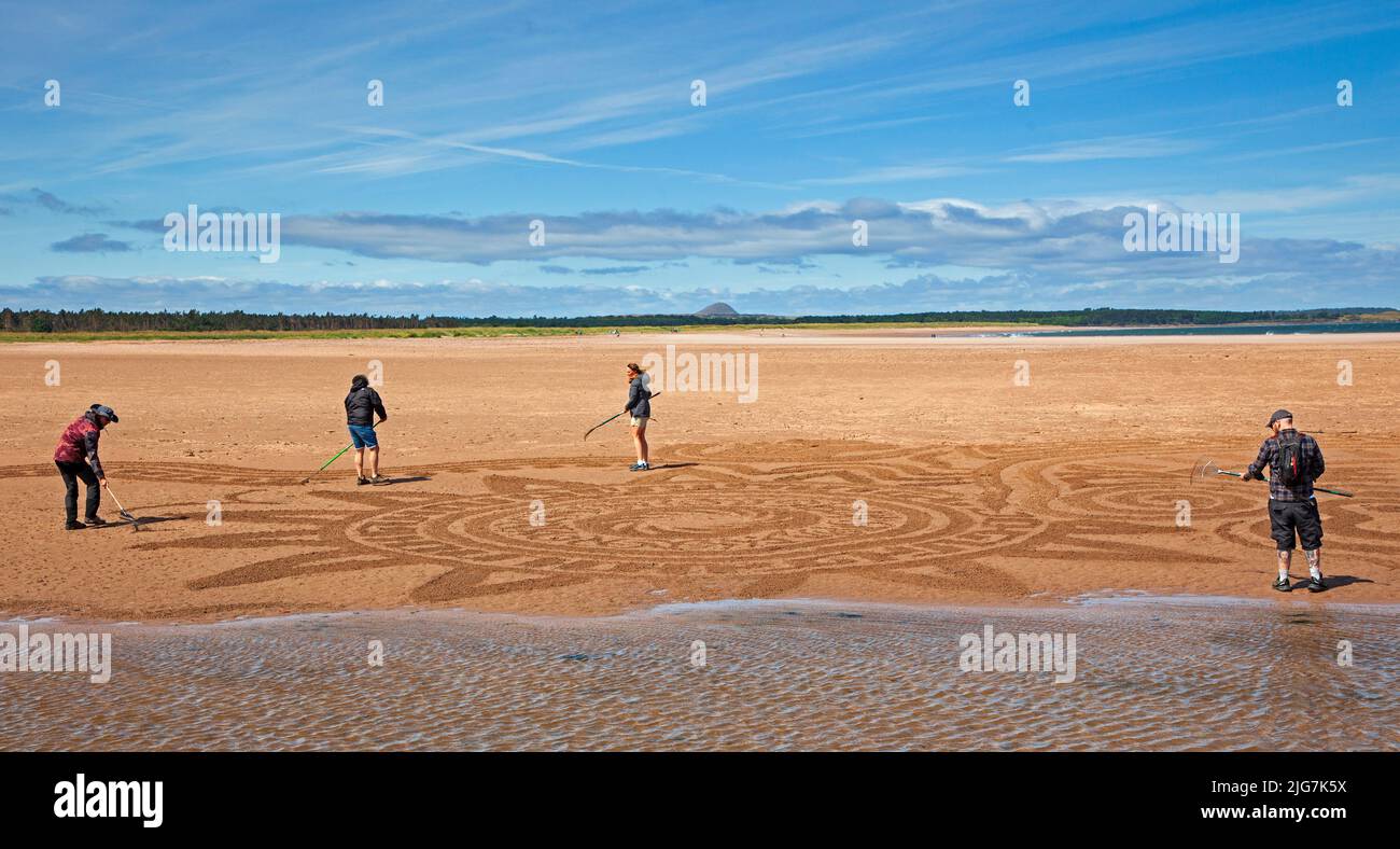 Belhaven Bay, East Lothian, Écosse, Royaume-Uni. 8th juillet 2022. Le dessin de sable au Festival européen d'art terrestre et aux Championnats de superposition de pierres, gérés par James Craig page, c'était la journée de la santé mentale et du bien-être, les artistes contributeurs sont : John Foreman du pays de Galles, Pedro Duran d'Espagne, Arron Tierney d'Écosse, Steve Winter d'Afrique du Sud. Le soleil et le vent fort à 38 km/h et les rafales potentielles de 66 km/h ont rendu la vie un peu difficile. Le festival d'une semaine se termine ce week-end. Crédit : Arch White/alamy Live News Banque D'Images