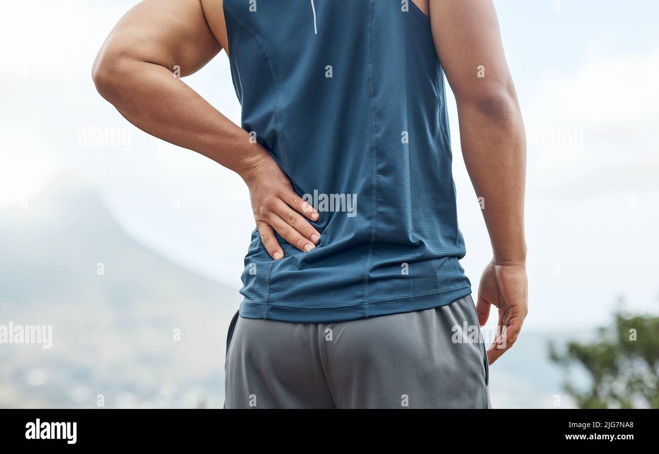 Je l'ai vraiment senti dans mon dos. Photo d'un jeune homme sportif souffrant de douleurs dorsales lors d'une course. Banque D'Images