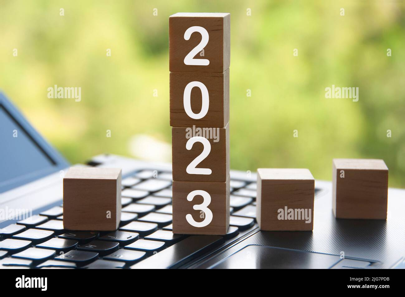 Nouvel an 2023 sur des blocs de bois au-dessus d'un ordinateur portable - concept du nouvel an Banque D'Images