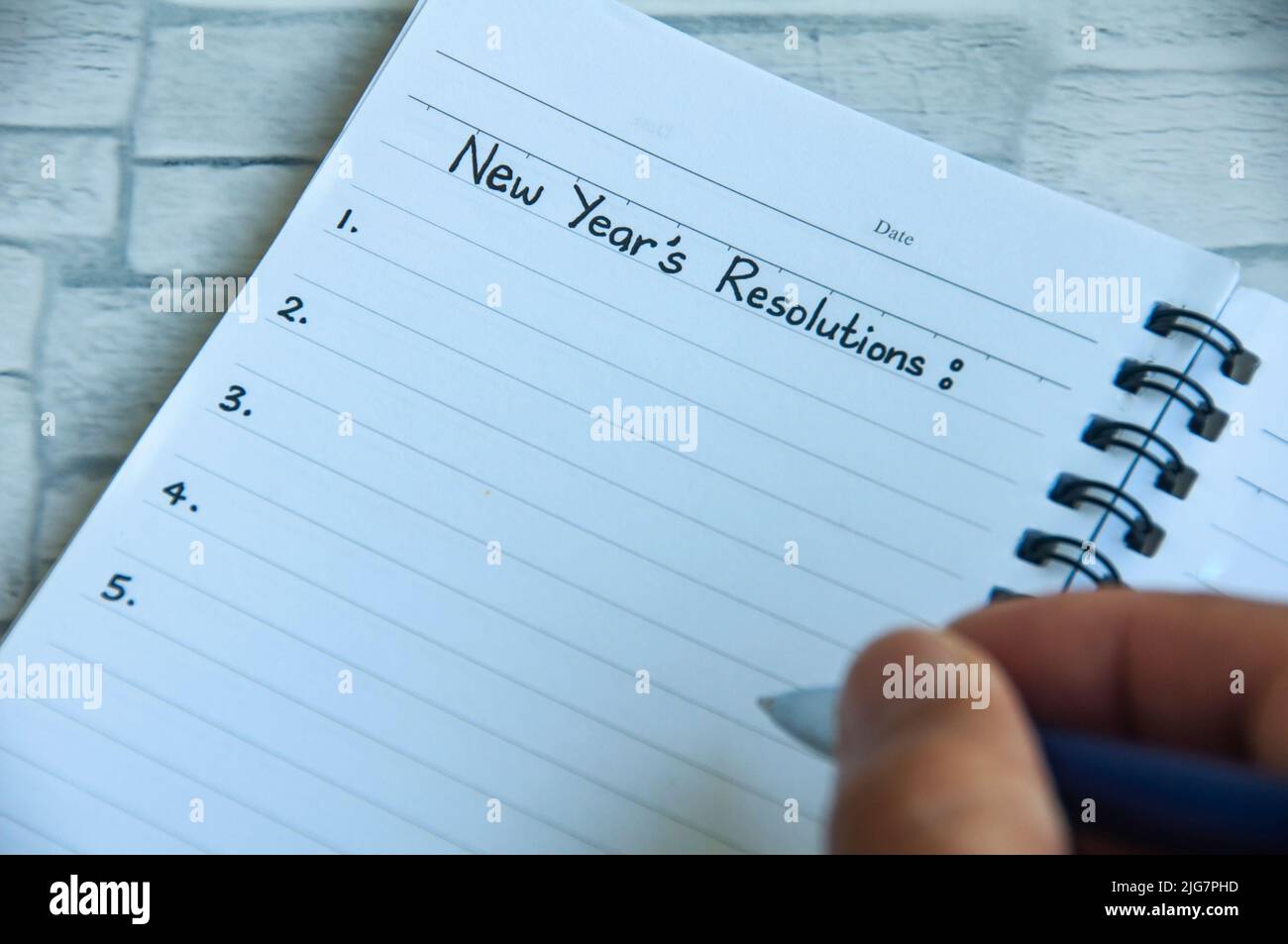 Écrire à la main le texte des résolutions du nouvel an sur le bloc-notes. Concept de résolution de la nouvelle année Banque D'Images
