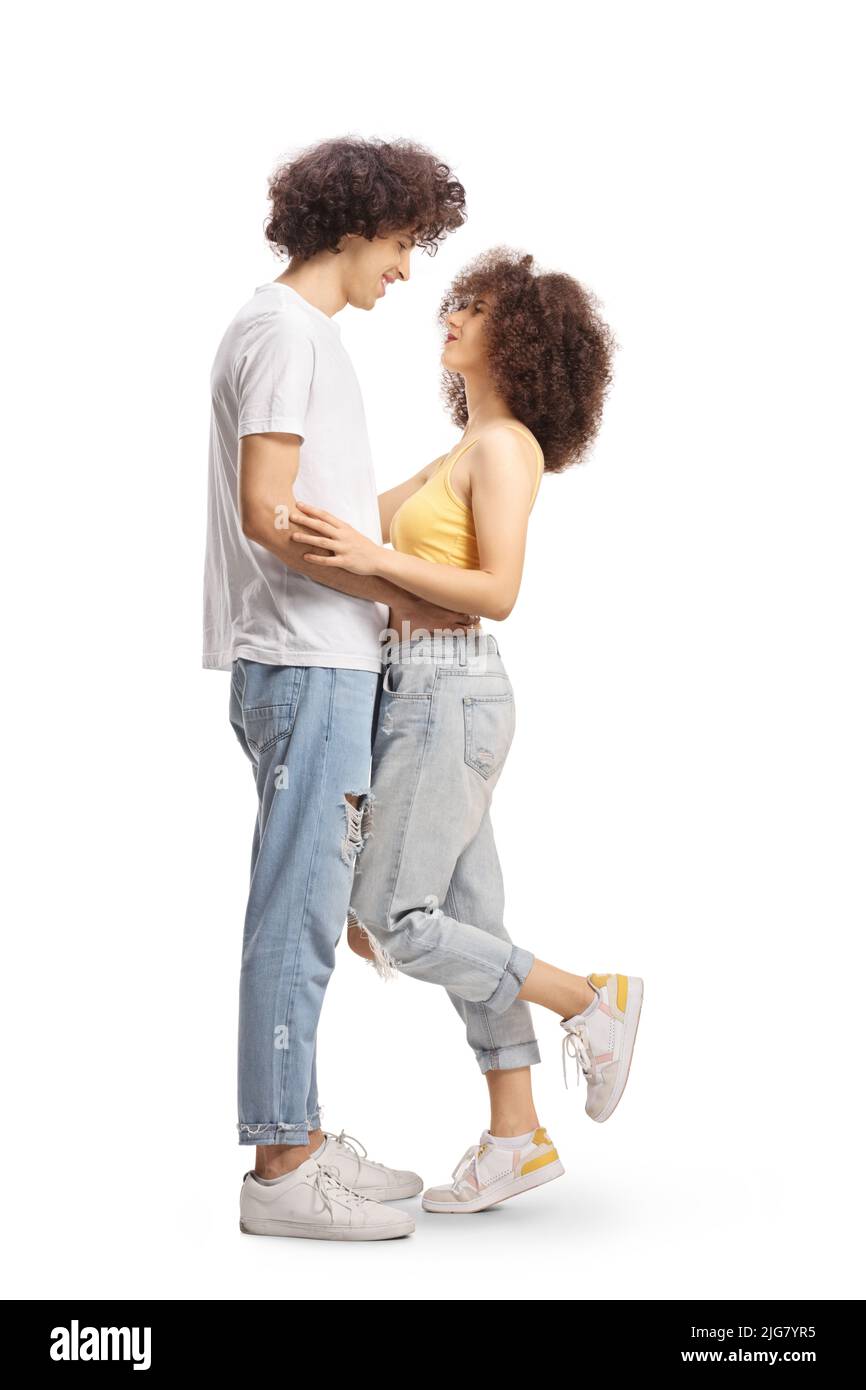 Photo de profil pleine longueur d'un jeune couple décontracté amoureux se portant et regardant l'un l'autre isolé sur fond blanc Banque D'Images