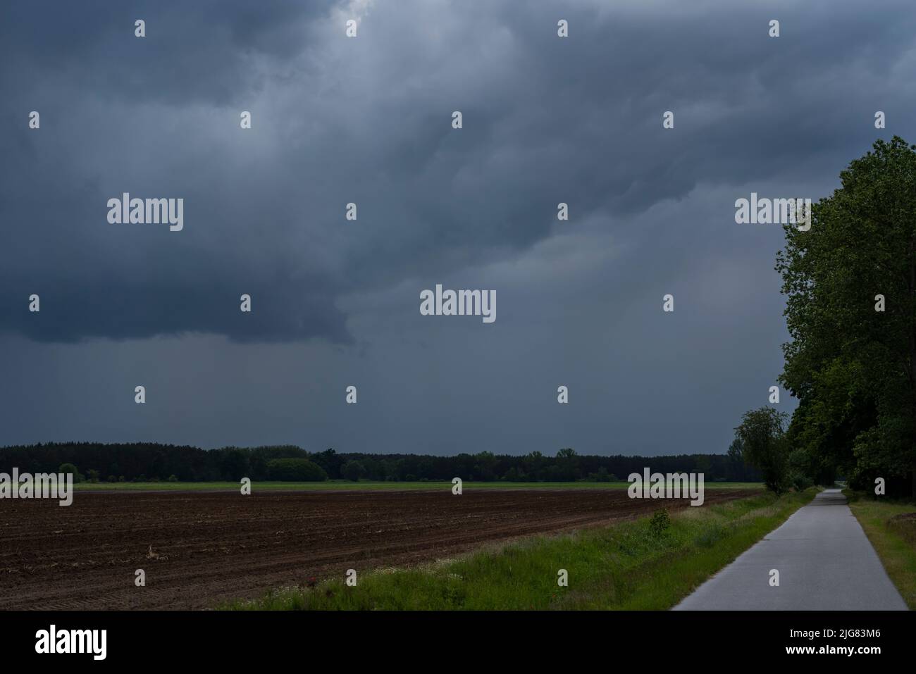 De grandes pluies nuages sur un sentier de cycle juste avant une mauvaise tempête, côté gauche des terres agricoles Banque D'Images